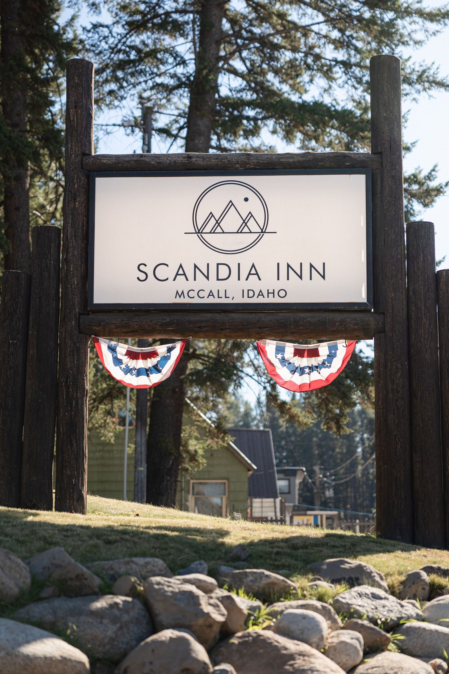 Wooden entrance sign for Scandia Inn in McCall Idaho with patriotic bunting decorations.