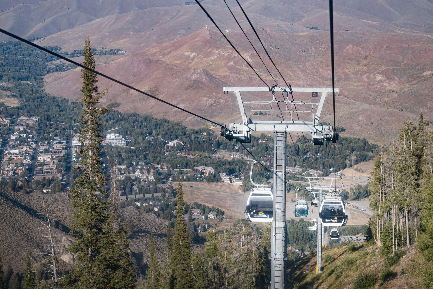 Ski lift gondolas and cables stretching across a mountain landscape with scenic valley views.