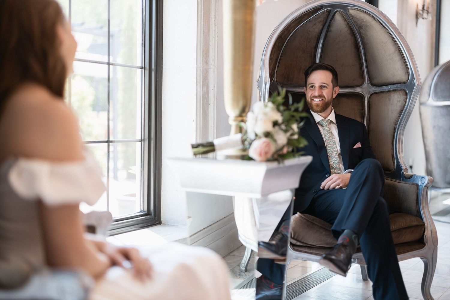 Wedding portraits captured in elegant indoor setting with vintage furniture and natural lighting.