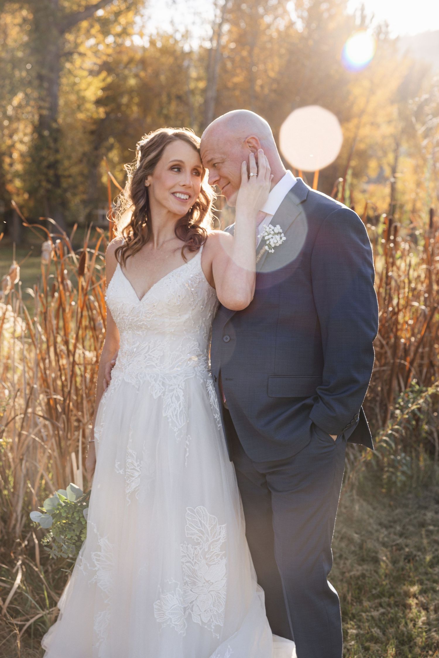A romantic wedding moment captured in golden hour light with fall foliage.