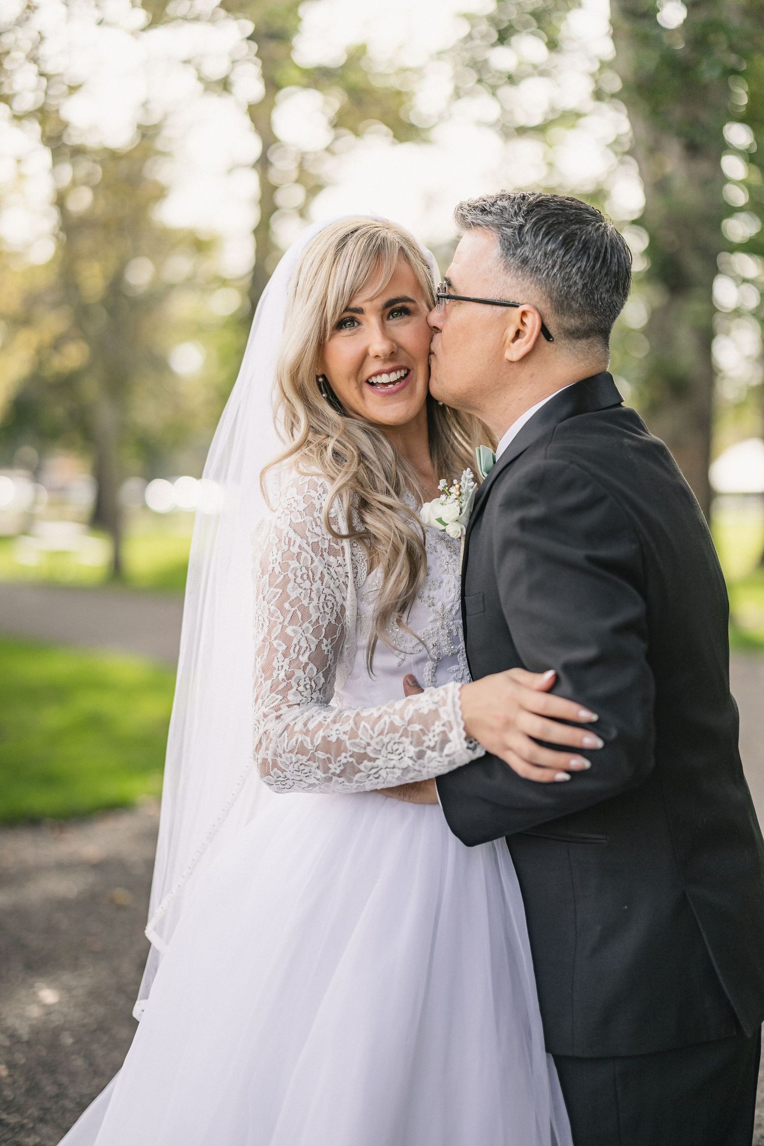 Tender moment captured between newlyweds in an outdoor park setting.