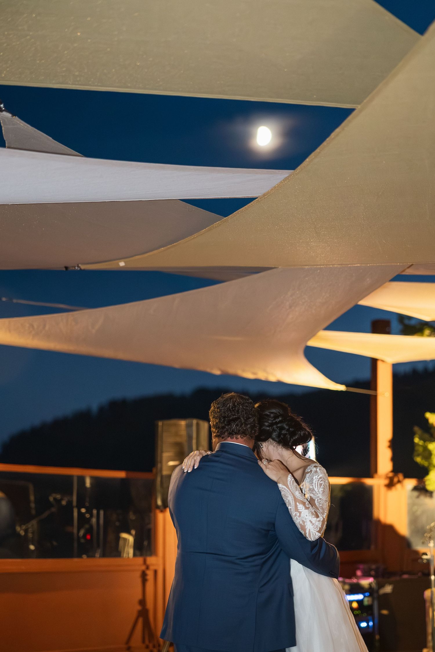 Romantic dance under white canopy sails with evening lighting.