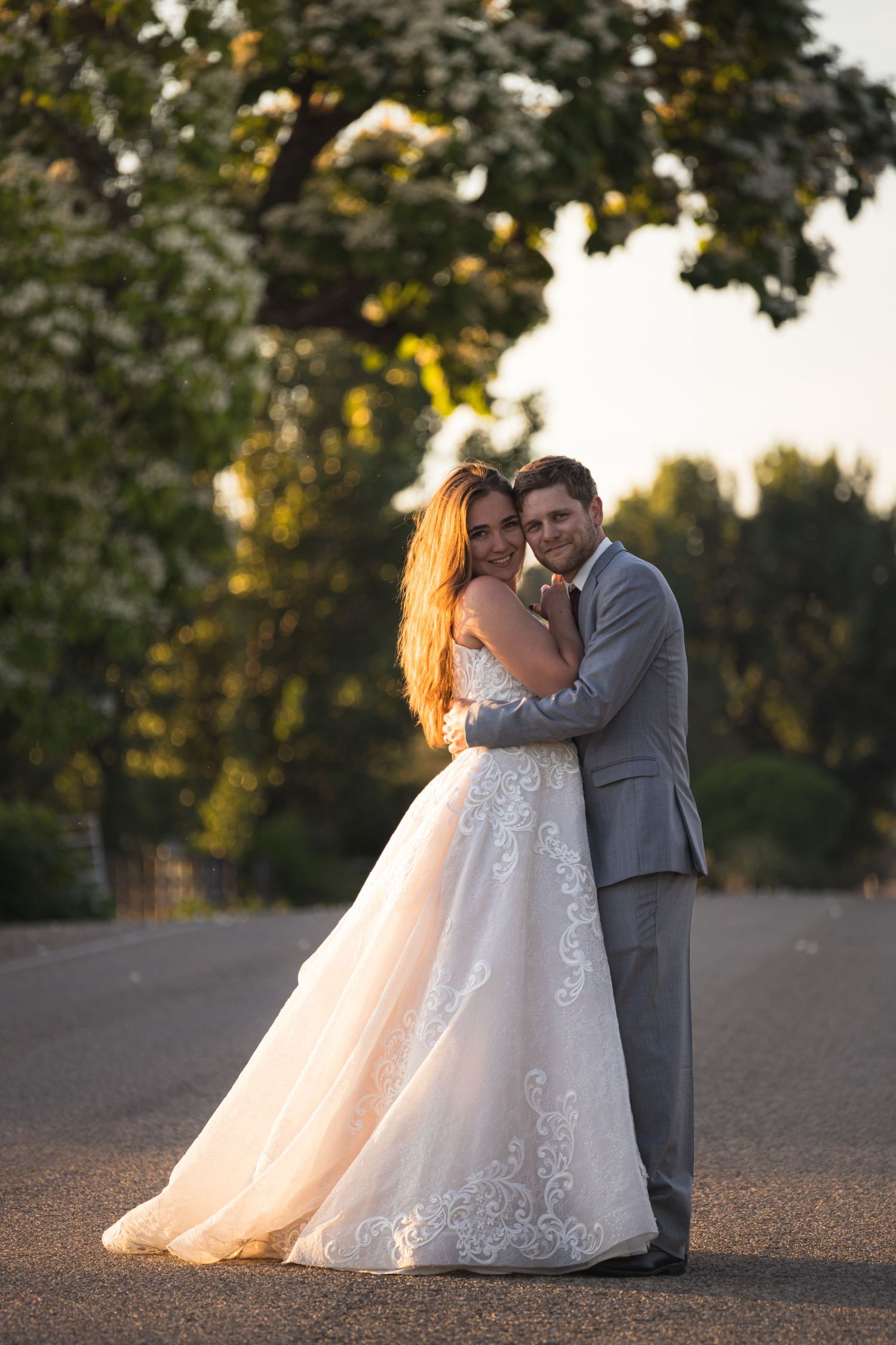 A romantic sunset wedding portrait with the couple embracing outdoors.