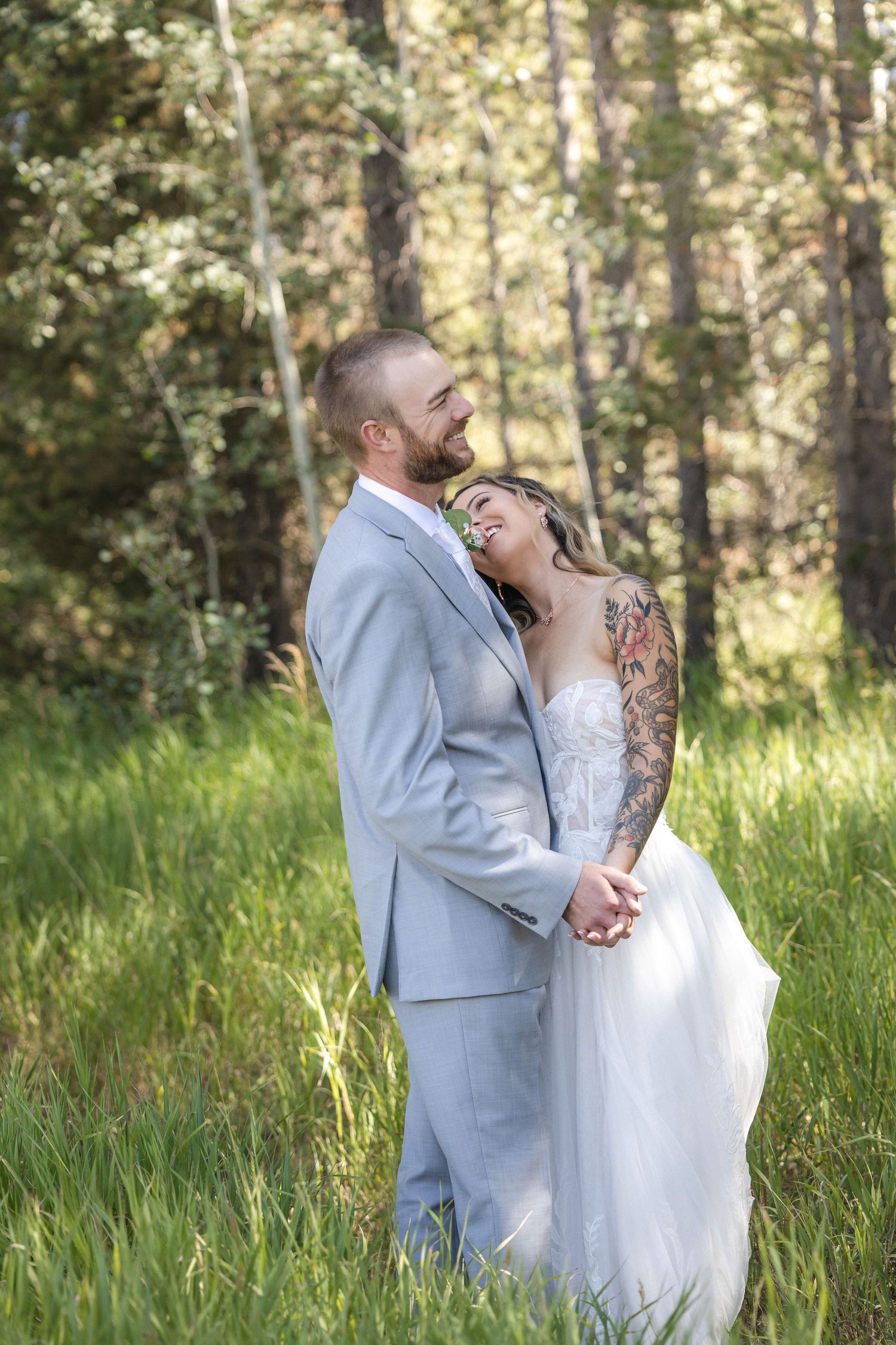 Newlyweds share intimate moments in a forest clearing during their wedding photoshoot.