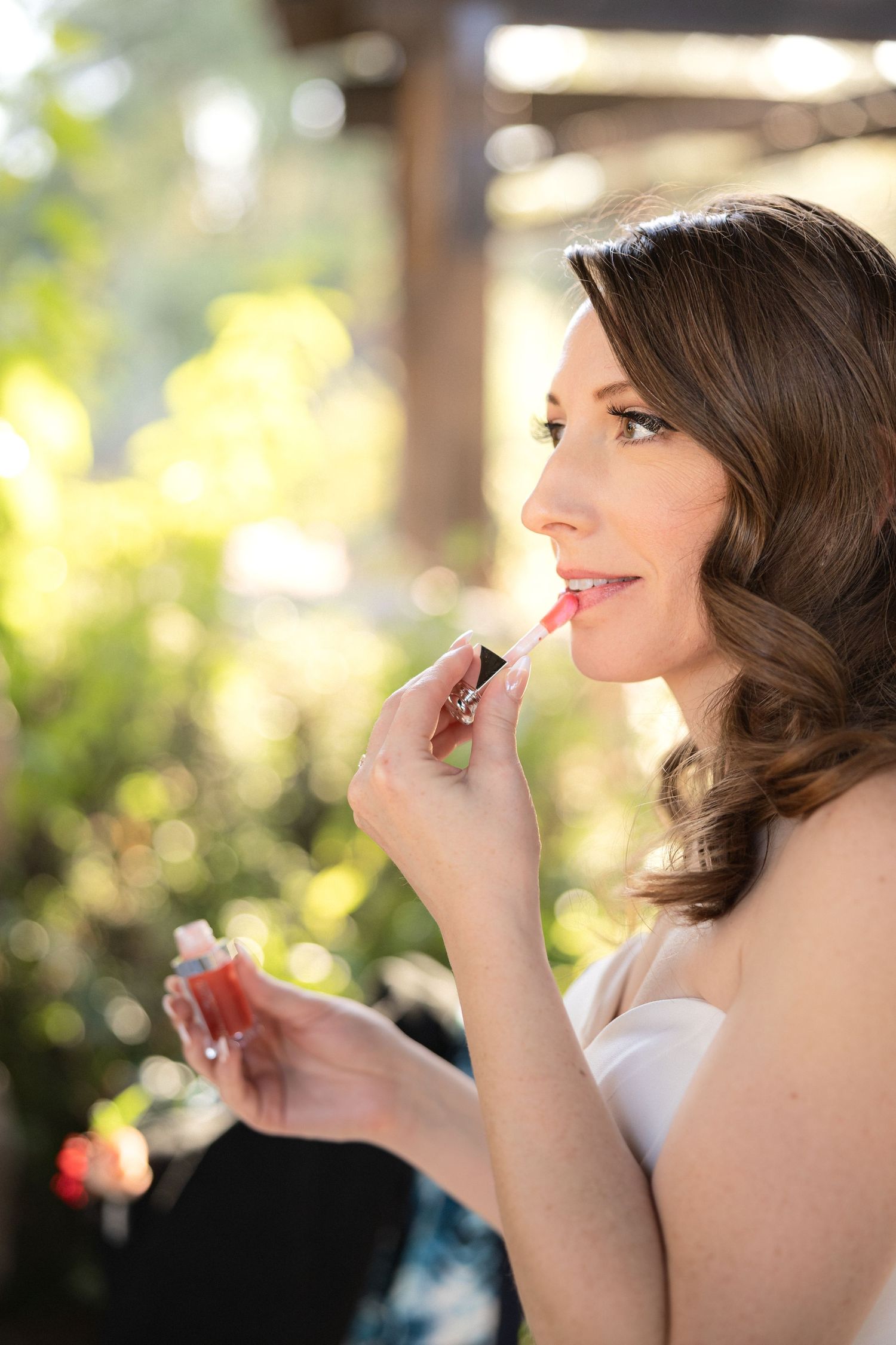 Close-up of bridal makeup application in natural lighting.