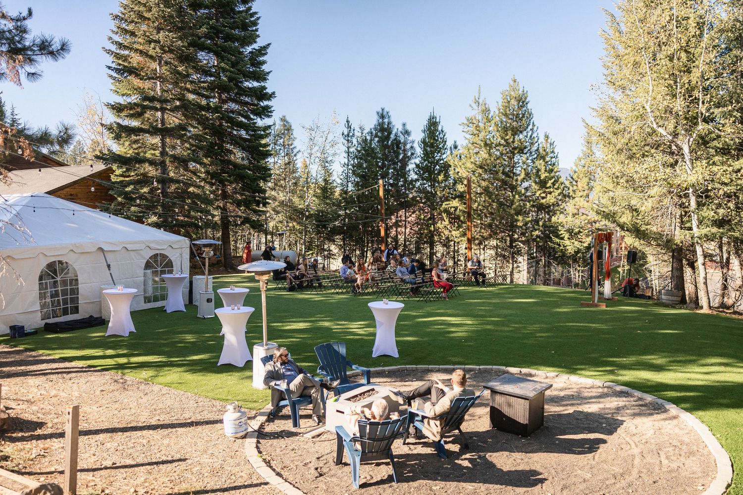 Panoramic view of an outdoor wedding venue with pine trees and mountain landscape.