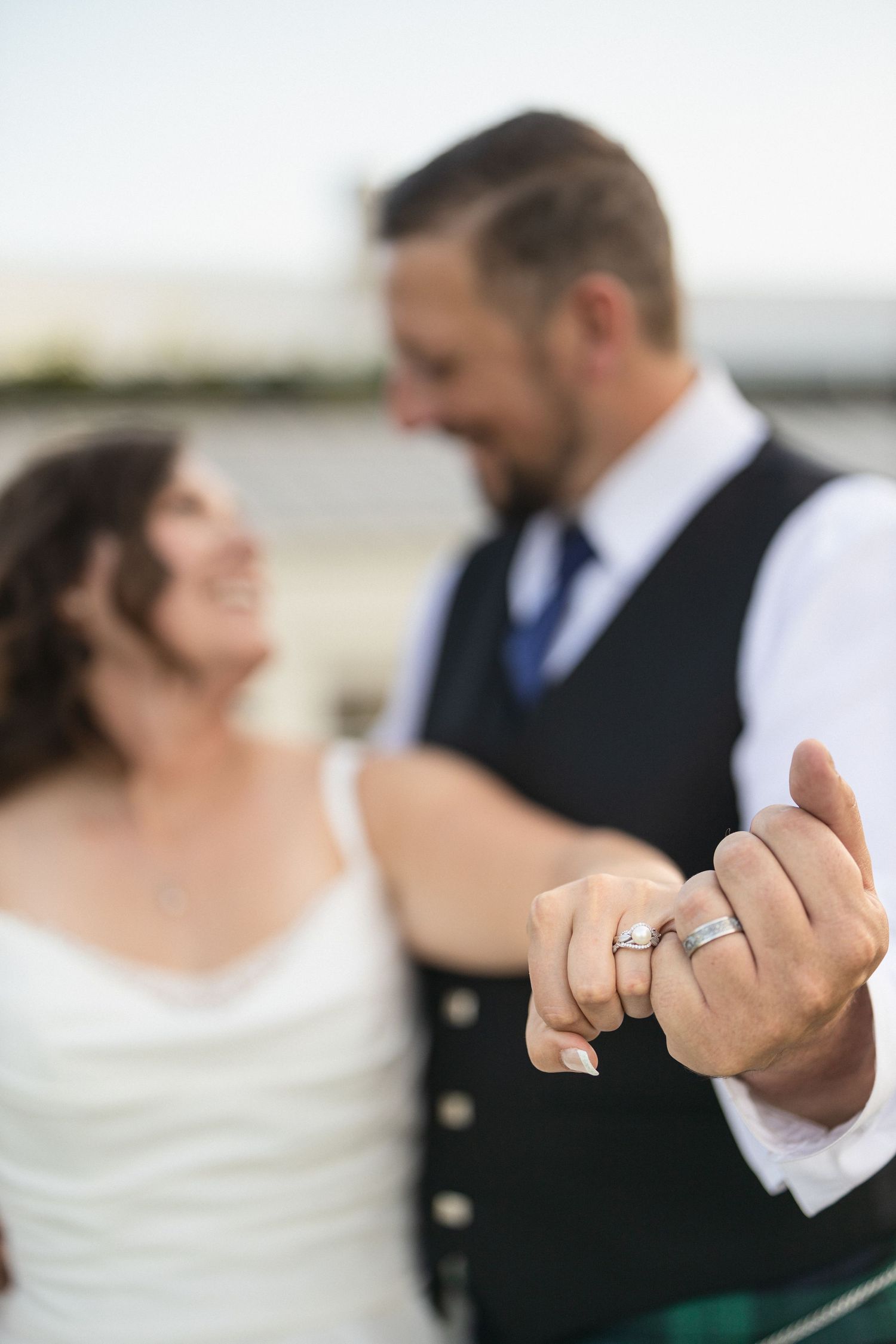 A tender moment between newlyweds showing their wedding rings.