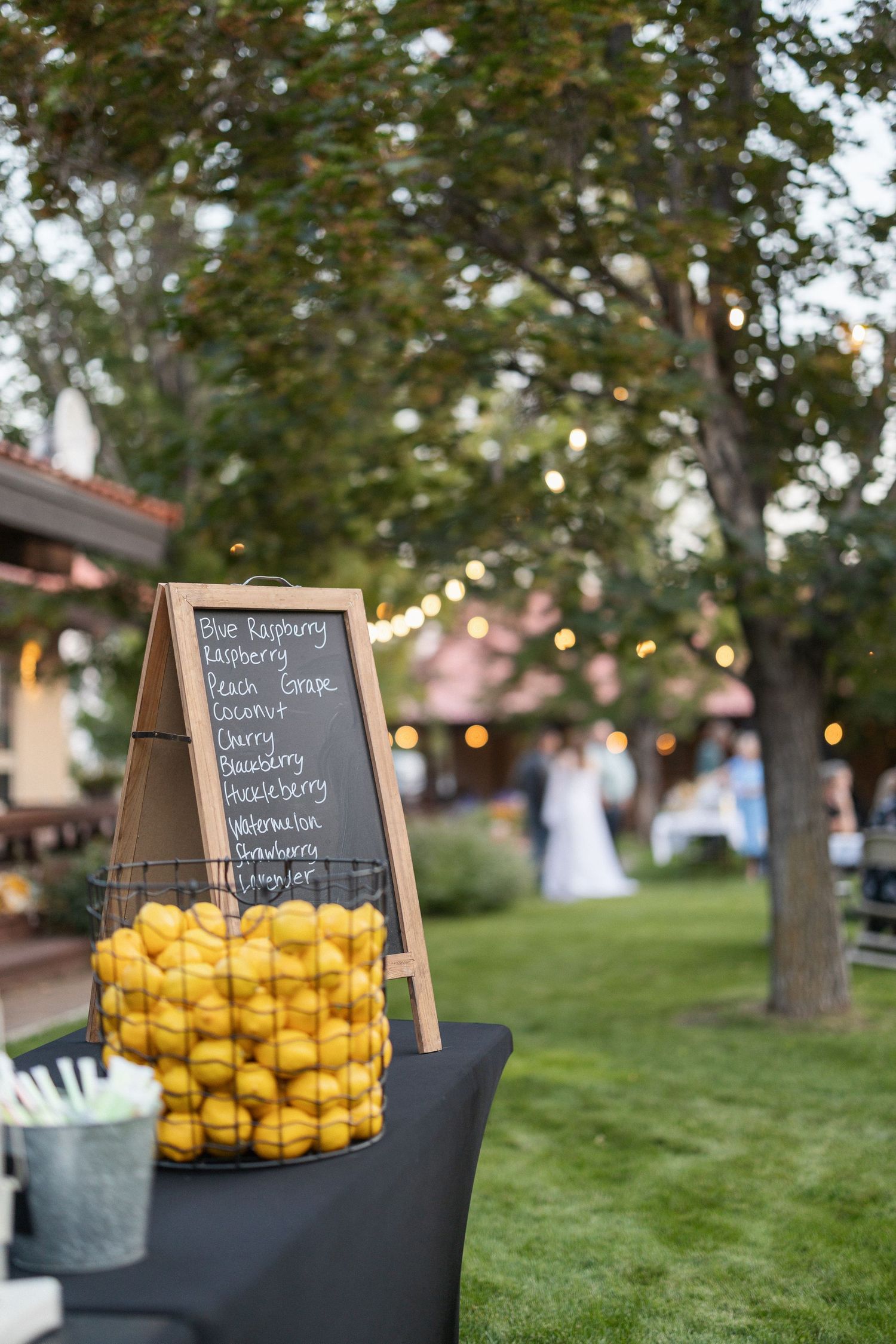 Fresh yellow lemons displayed in rustic baskets with chalkboard signs at an outdoor event.