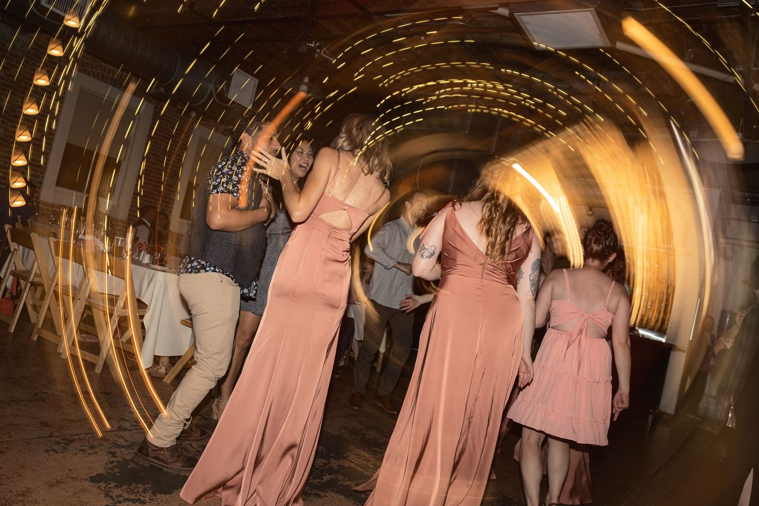 Wedding reception dance floor with dramatic lighting effects and guests dancing.