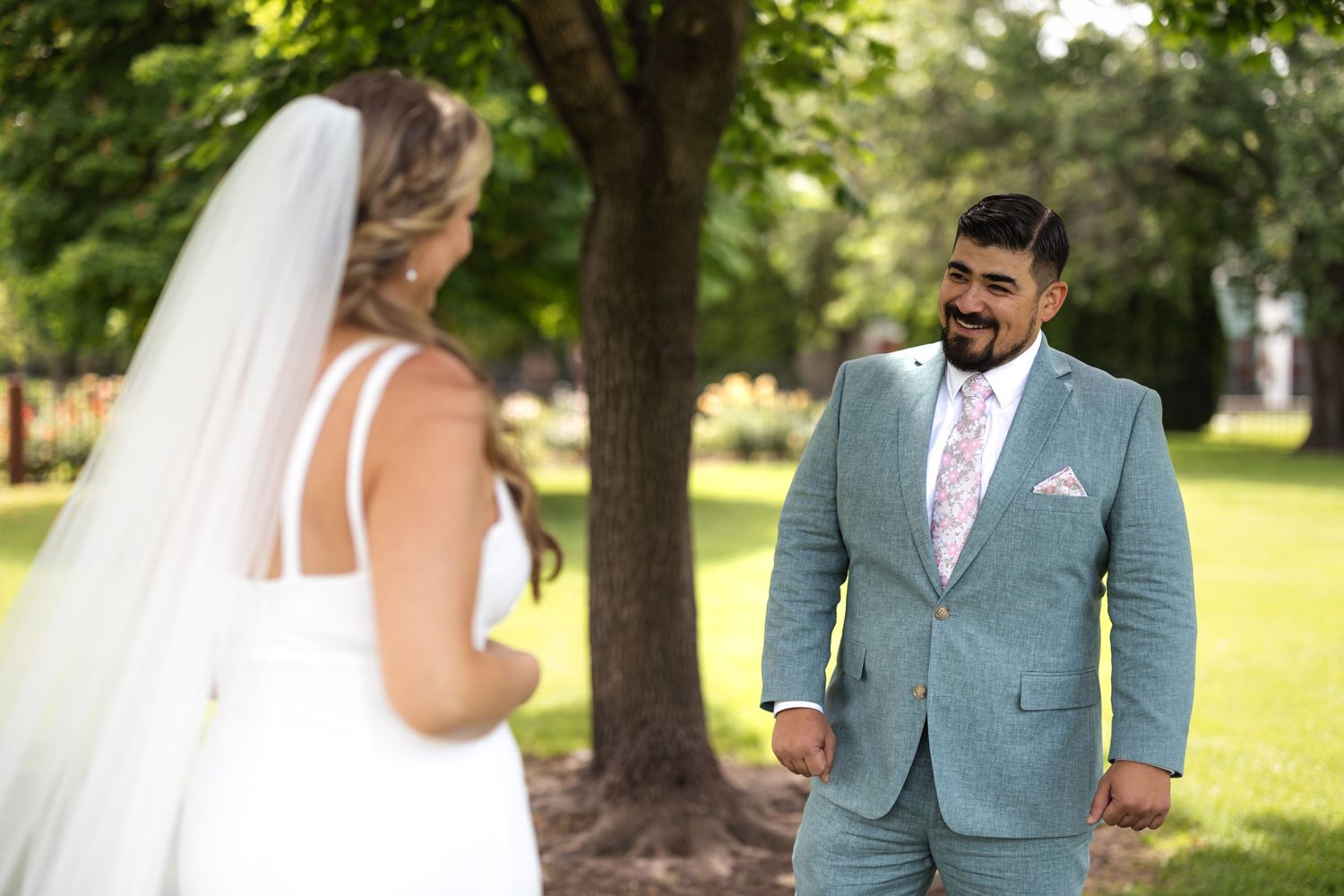 Romantic wedding scene with couple sharing a moment under trees.
