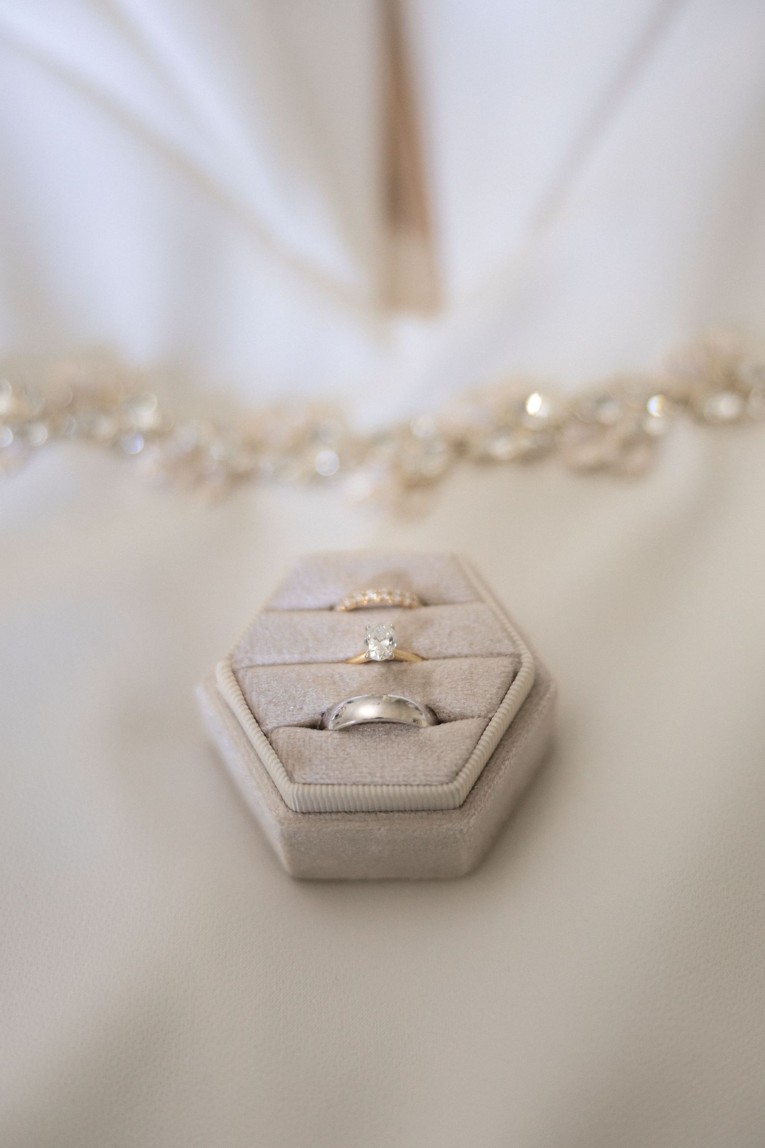 Wedding rings displayed in a light gray hexagonal ring box.