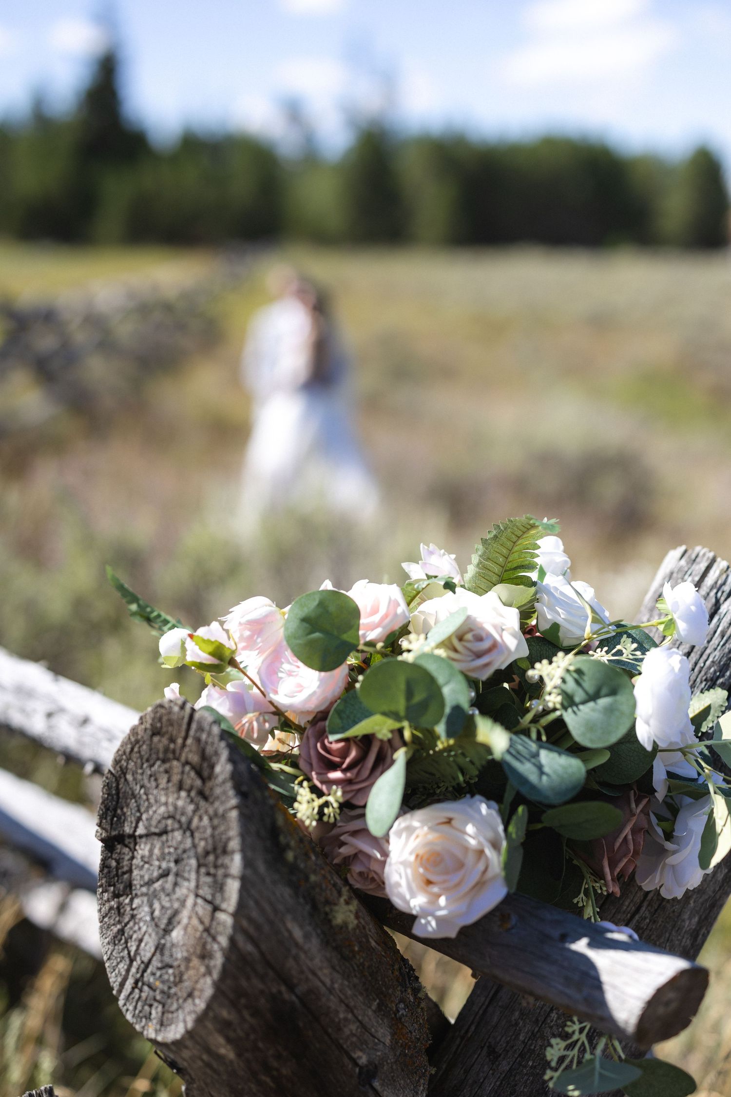 Beautiful floral wedding decorations arranged on rustic wooden logs.