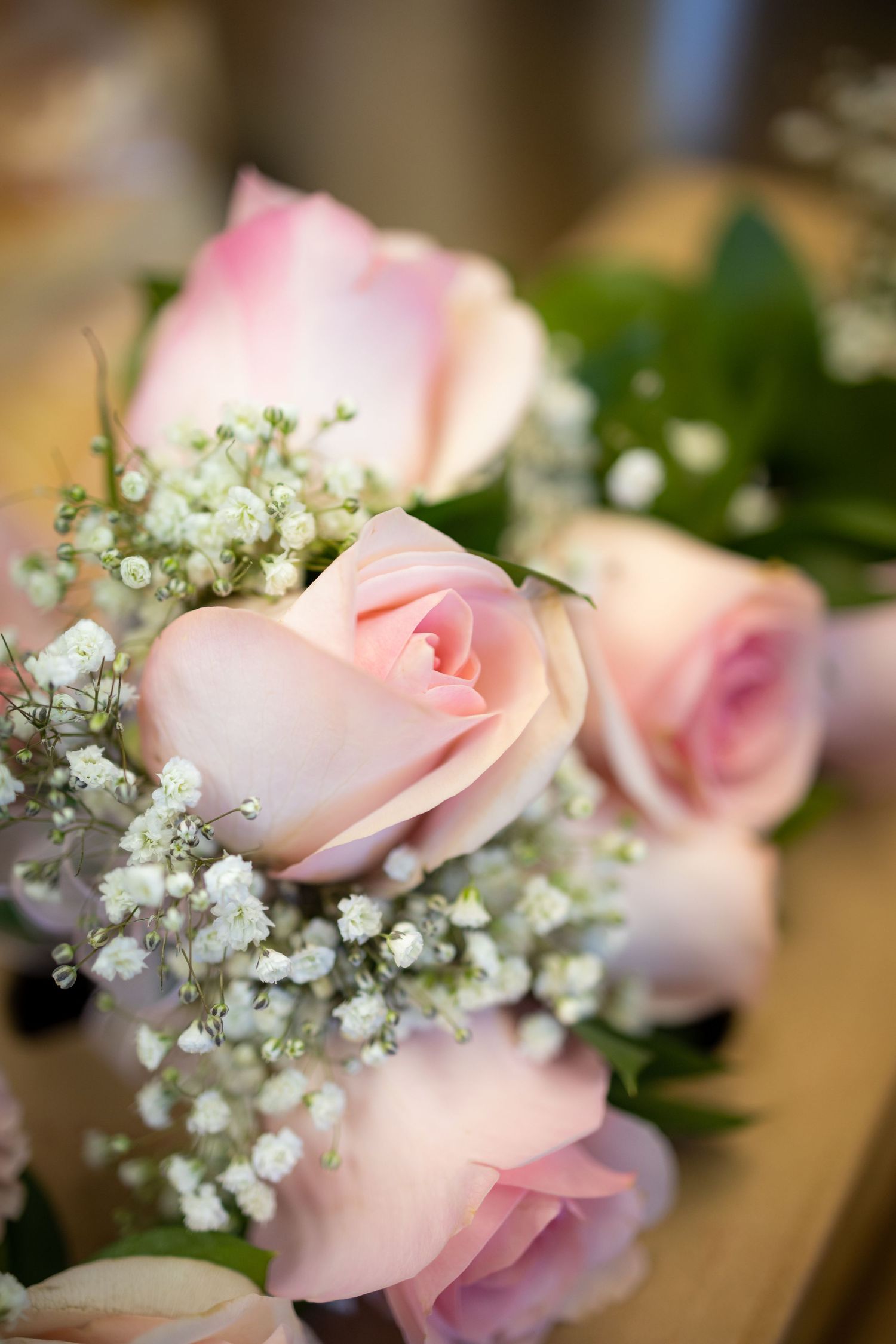 Delicate pink roses and baby's breath arranged in an elegant wedding bouquet.