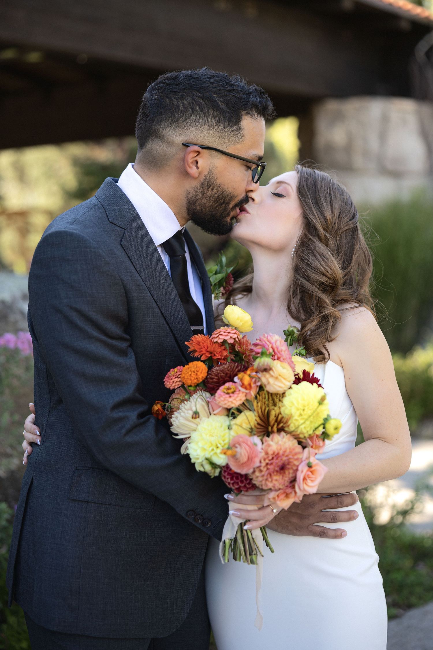 A romantic wedding moment captured with a colorful autumn bouquet.