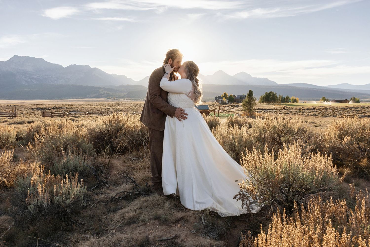 A romantic wedding photoshoot in a desert setting with mountains and golden light.