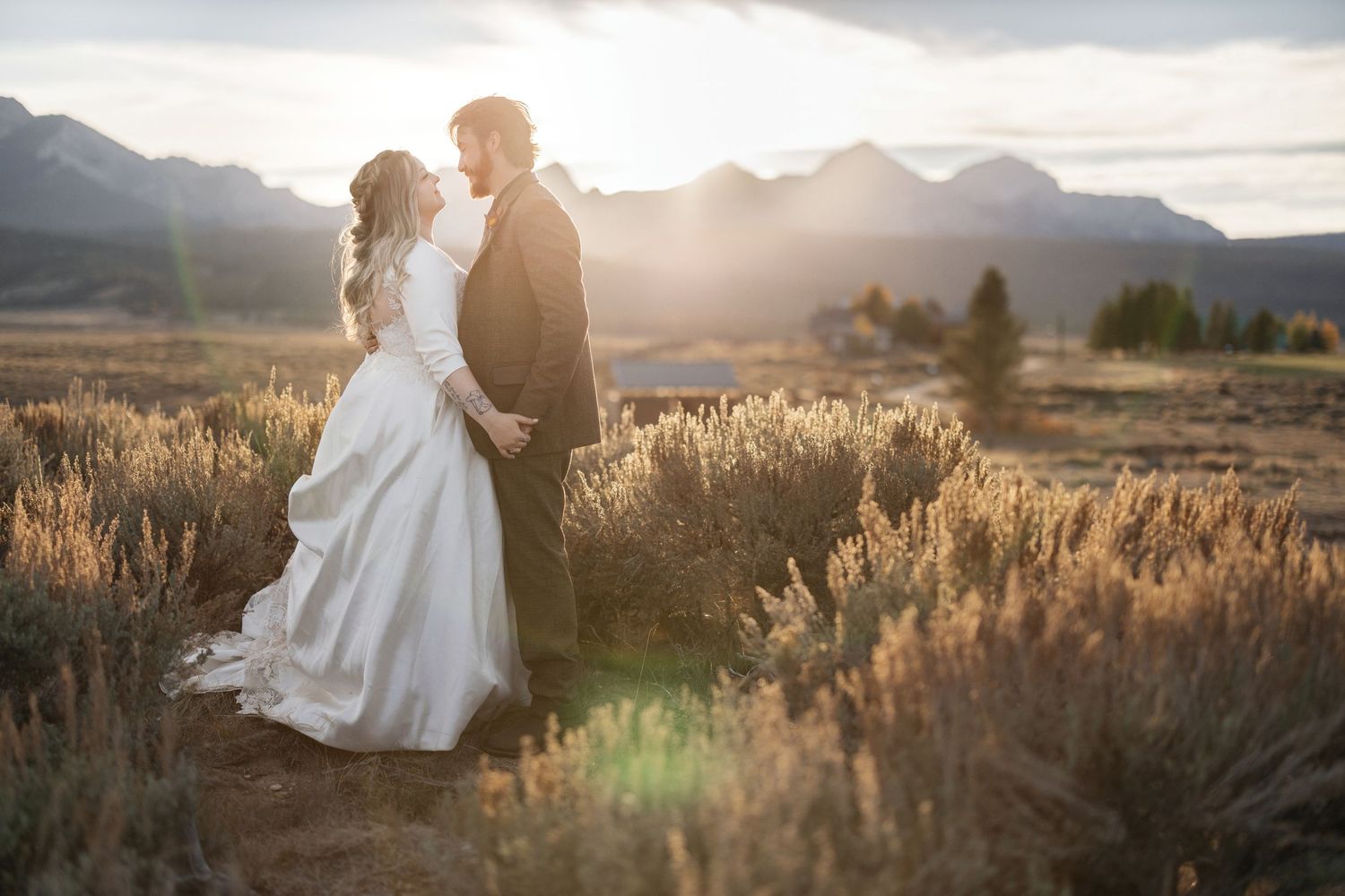 Romantic sunset photoshoot in desert landscape with mountain silhouettes.