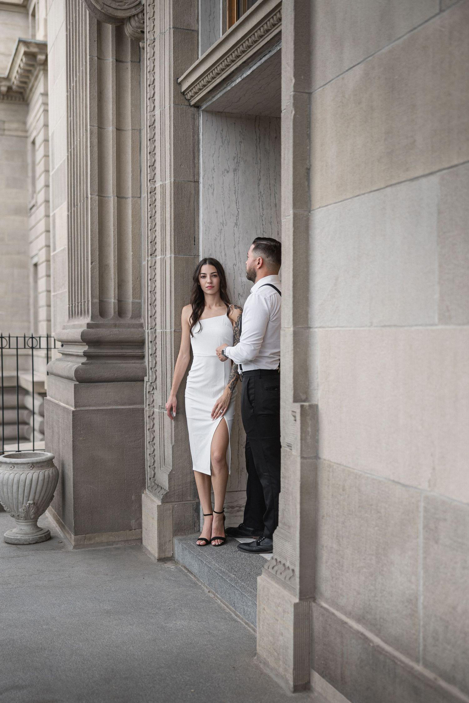 Stone colonnade with classical architectural details and concrete flooring.