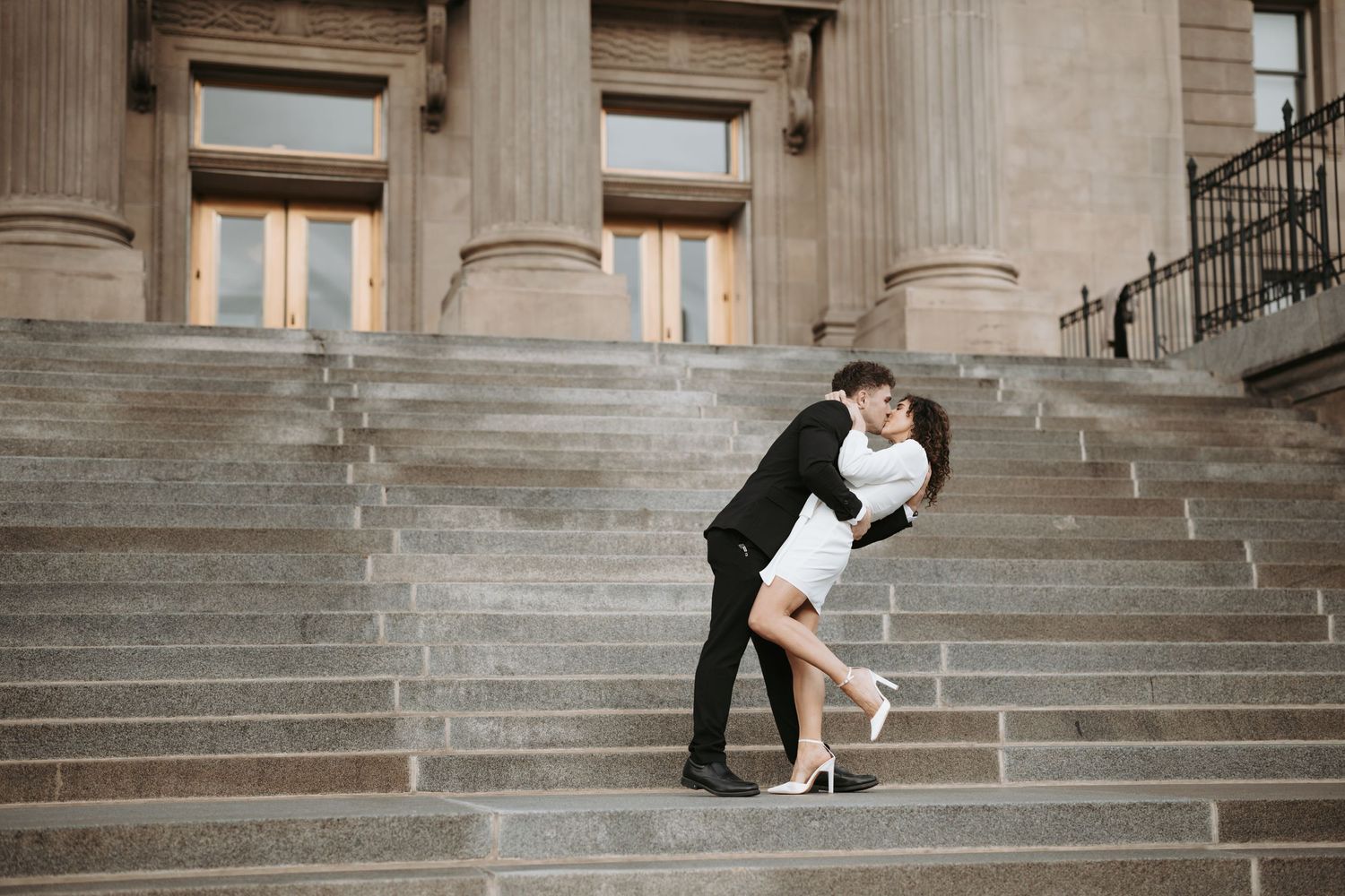 A romantic couple shares an intimate dance pose on stone steps.