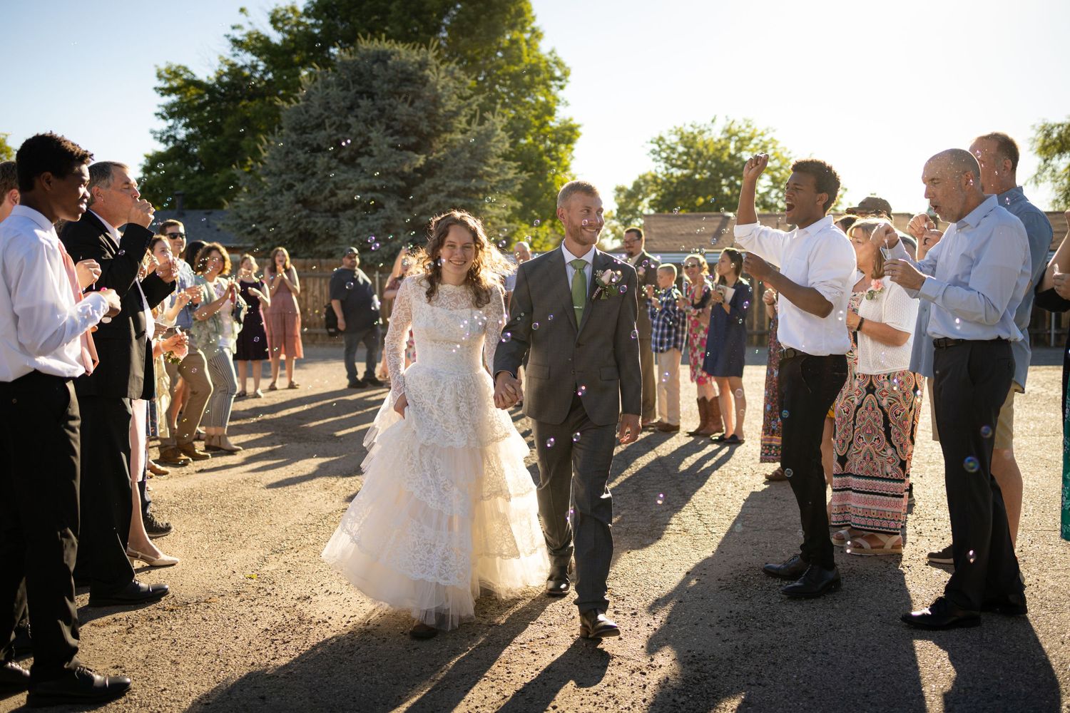 Guests form a receiving line at sunset as the couple walks through to applause.