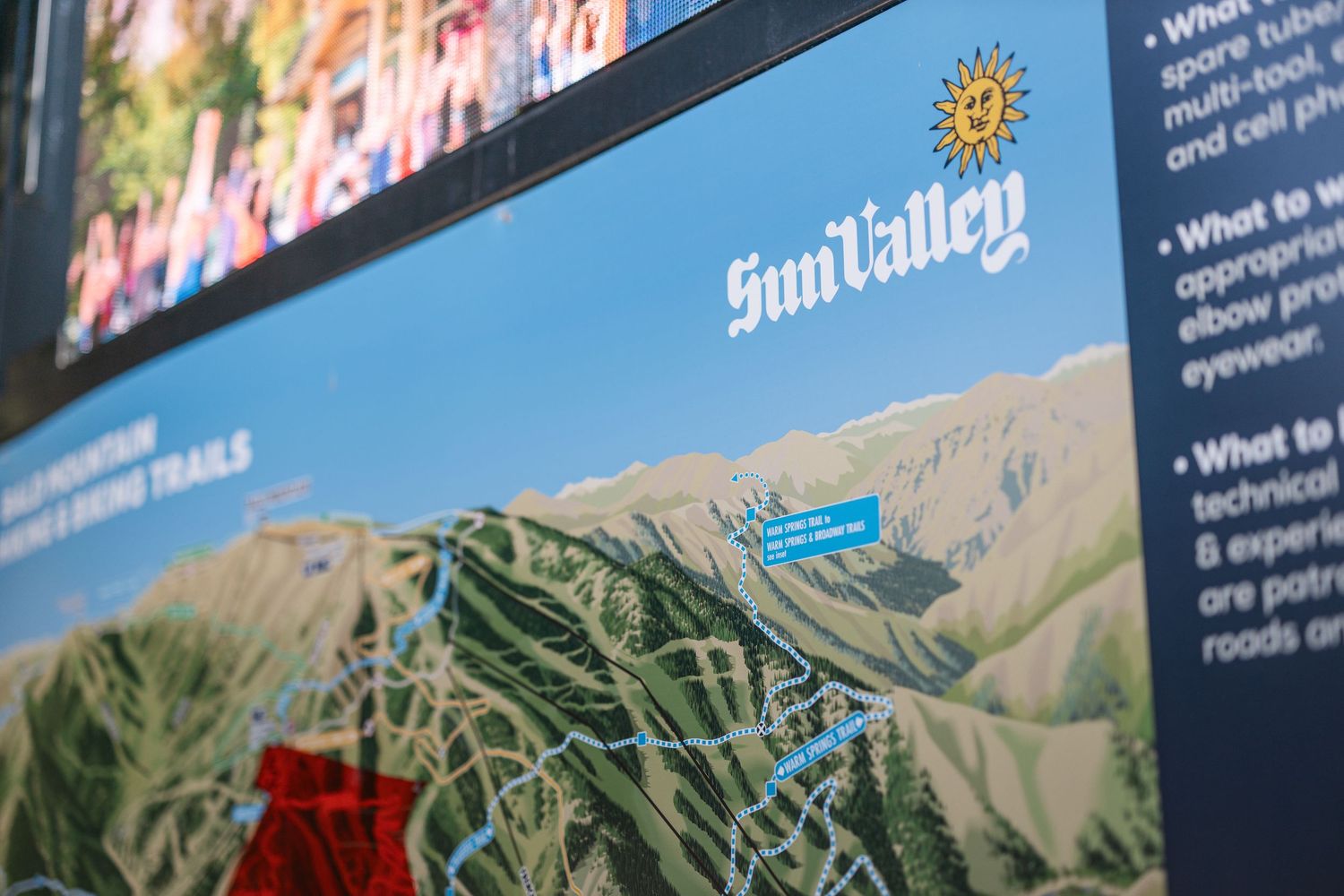 Scenic mountain landscape with informational signage and blue sky in the background.