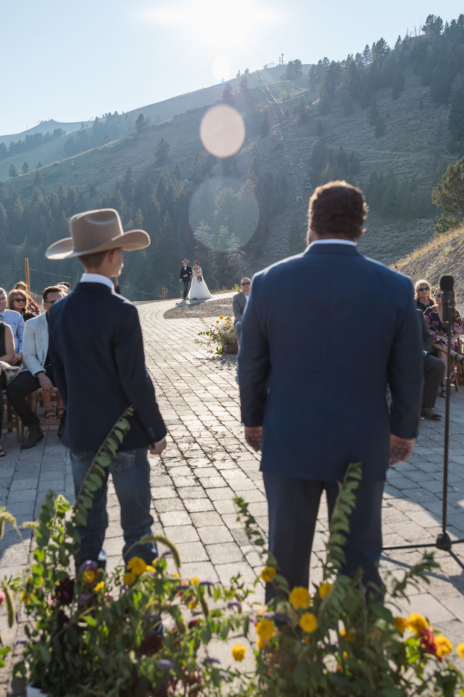 Wedding ceremony setup on a mountain overlook with wooden chairs and floral decorations.