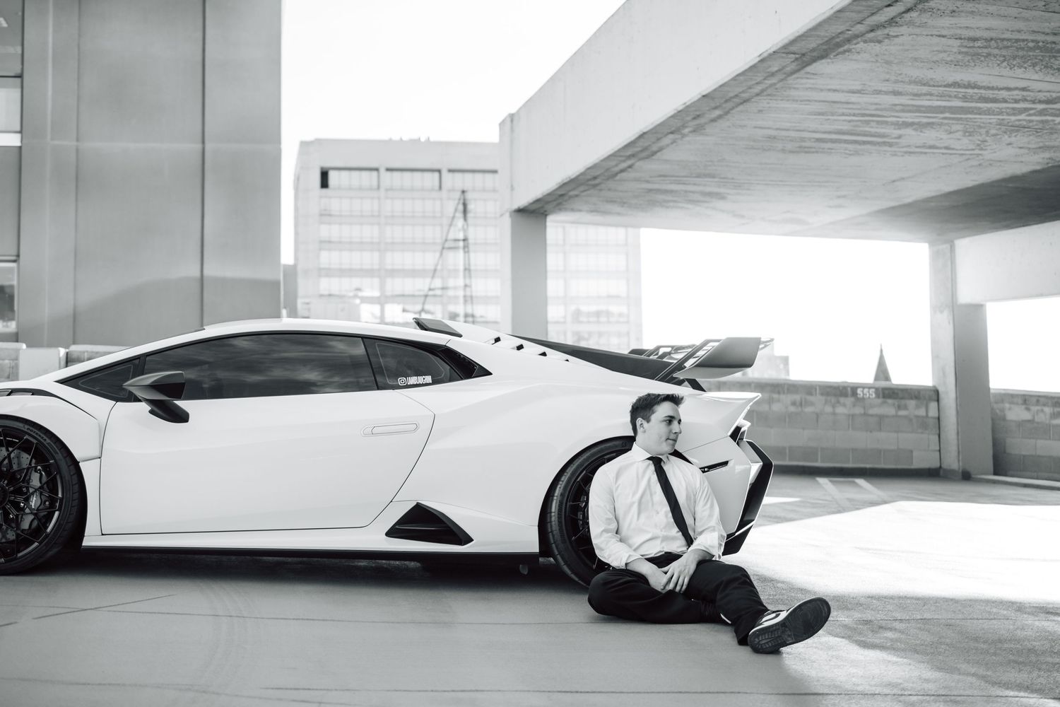 Four black and white photos showing a car parked in different angles inside a concrete parking garage.