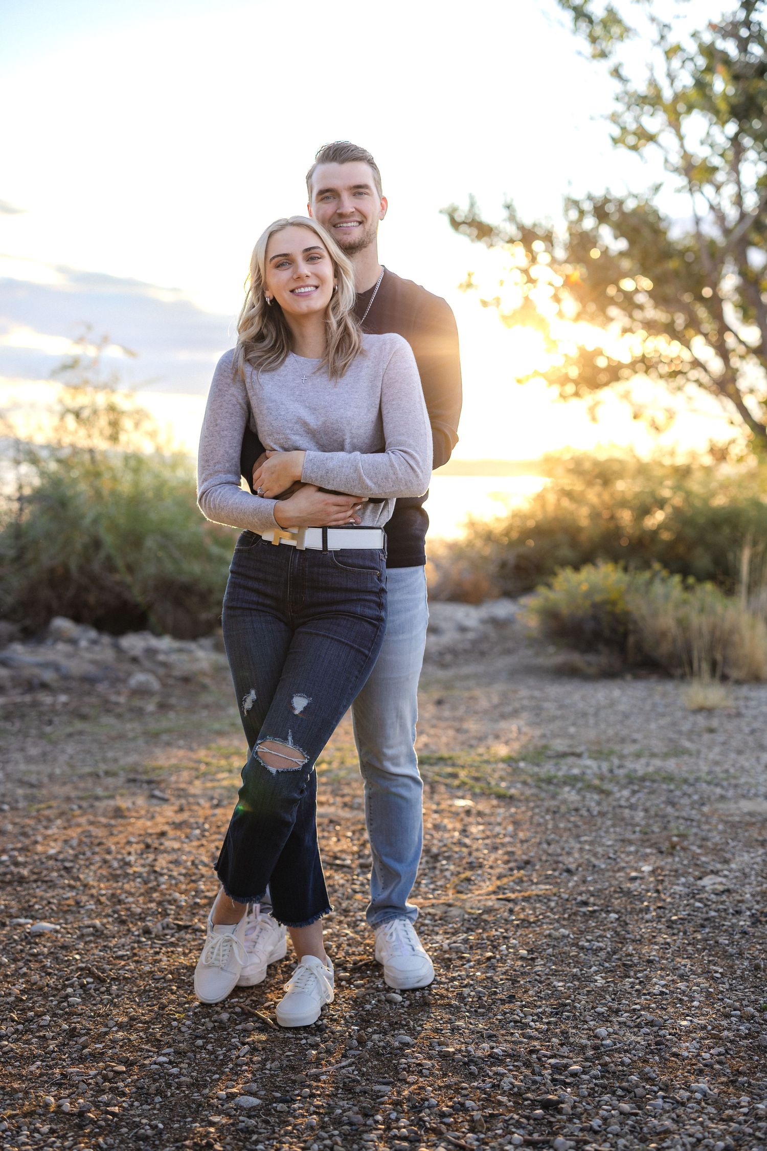 Couple sharing tender moment during sunset photoshoot in desert landscape.