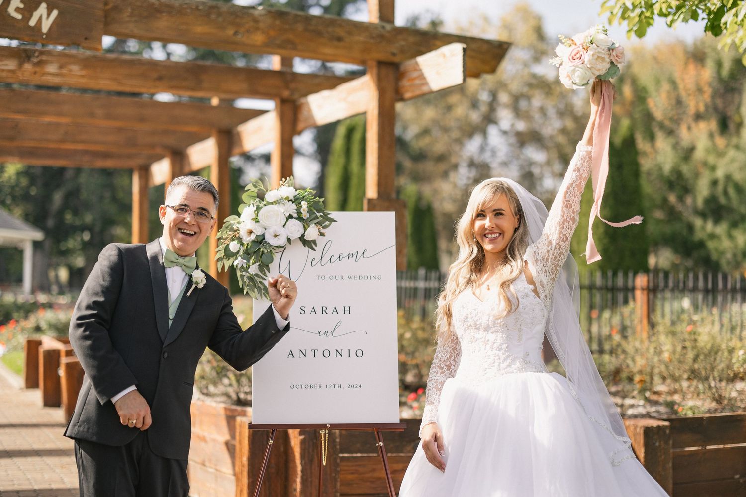 Joyful wedding celebration moment at outdoor venue with wooden pergola.