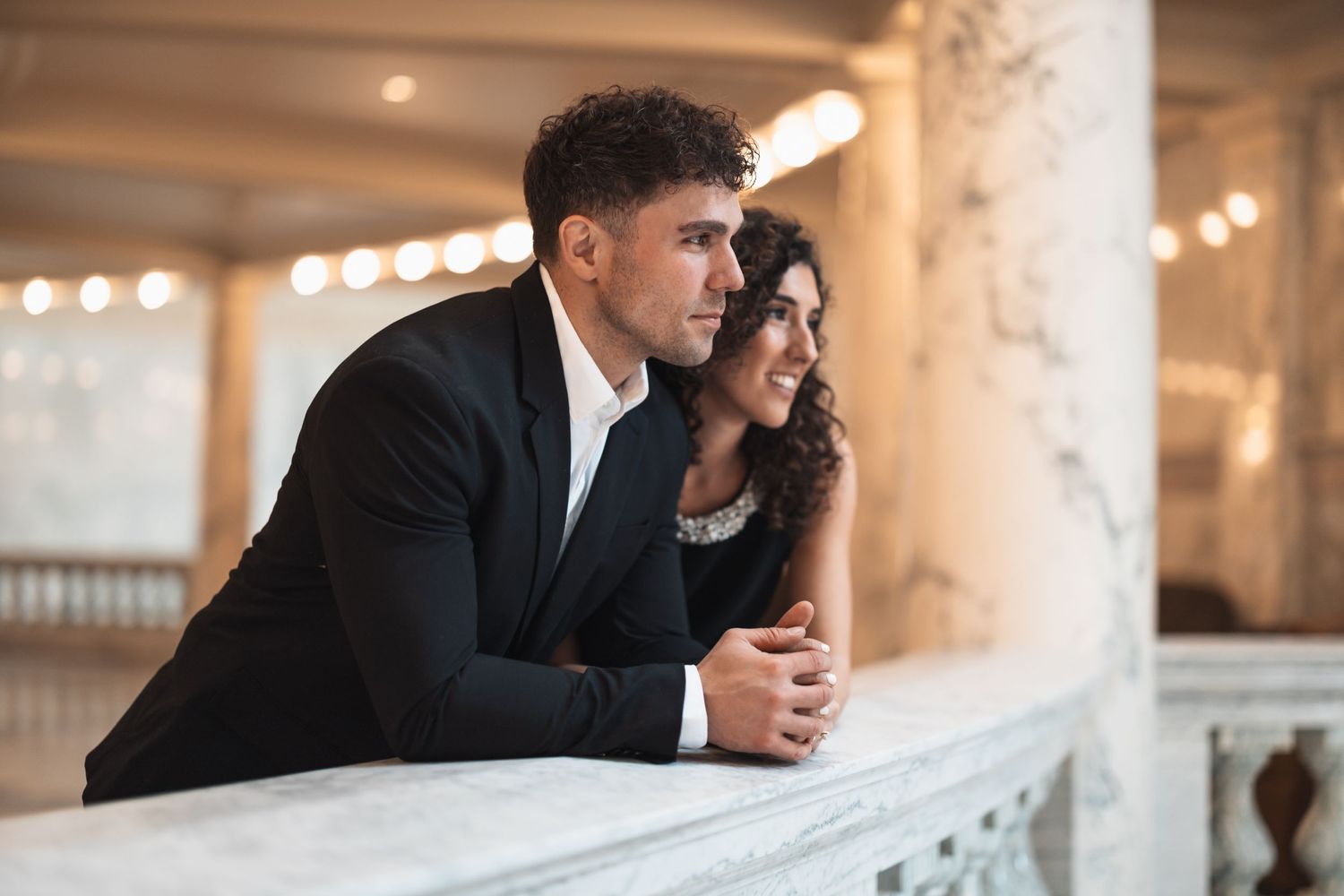 A romantic moment captured at an elegant venue with classical architectural details.