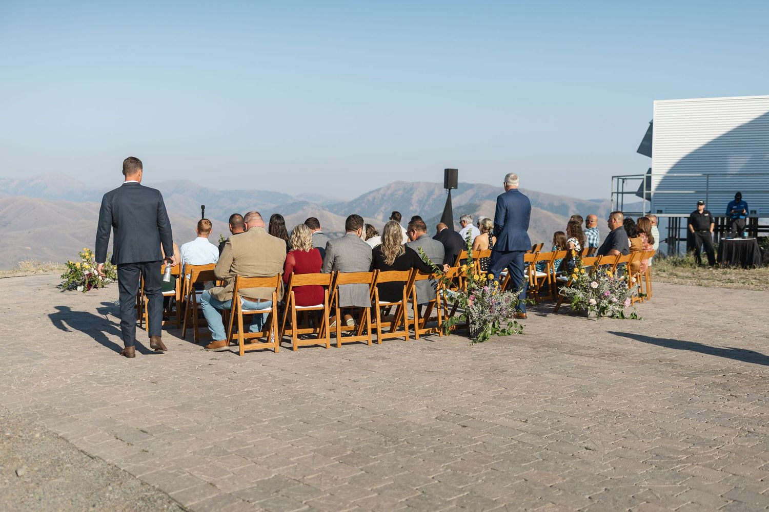 Panoramic view of outdoor wedding ceremony setup with mountain backdrop.