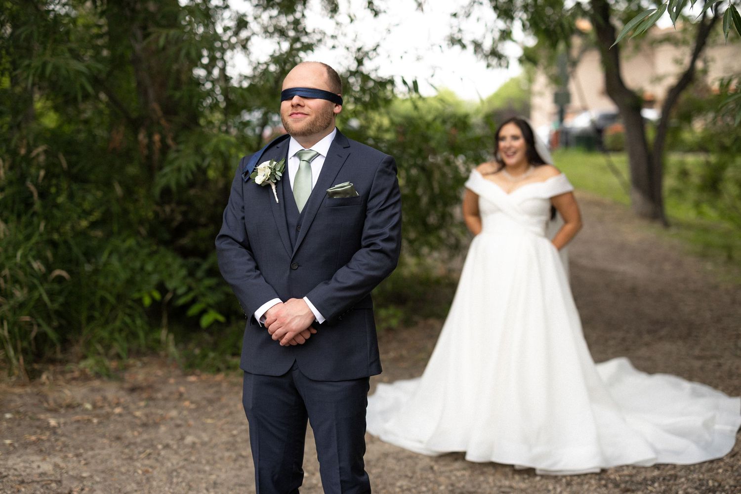 A couple shares their first look moment before their wedding ceremony in a wooded setting.