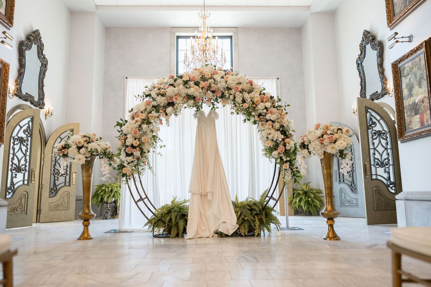 Elegant white church interior with floral arrangements and stained glass windows.