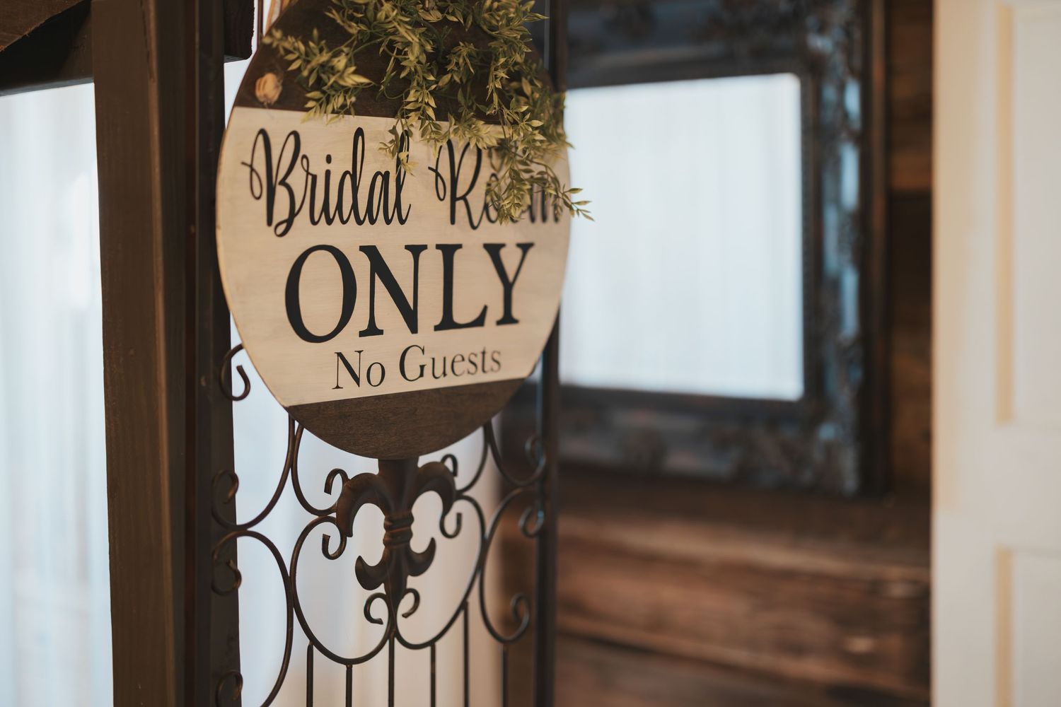 Vintage-style 'Bridal Room Only' sign on decorative frame.