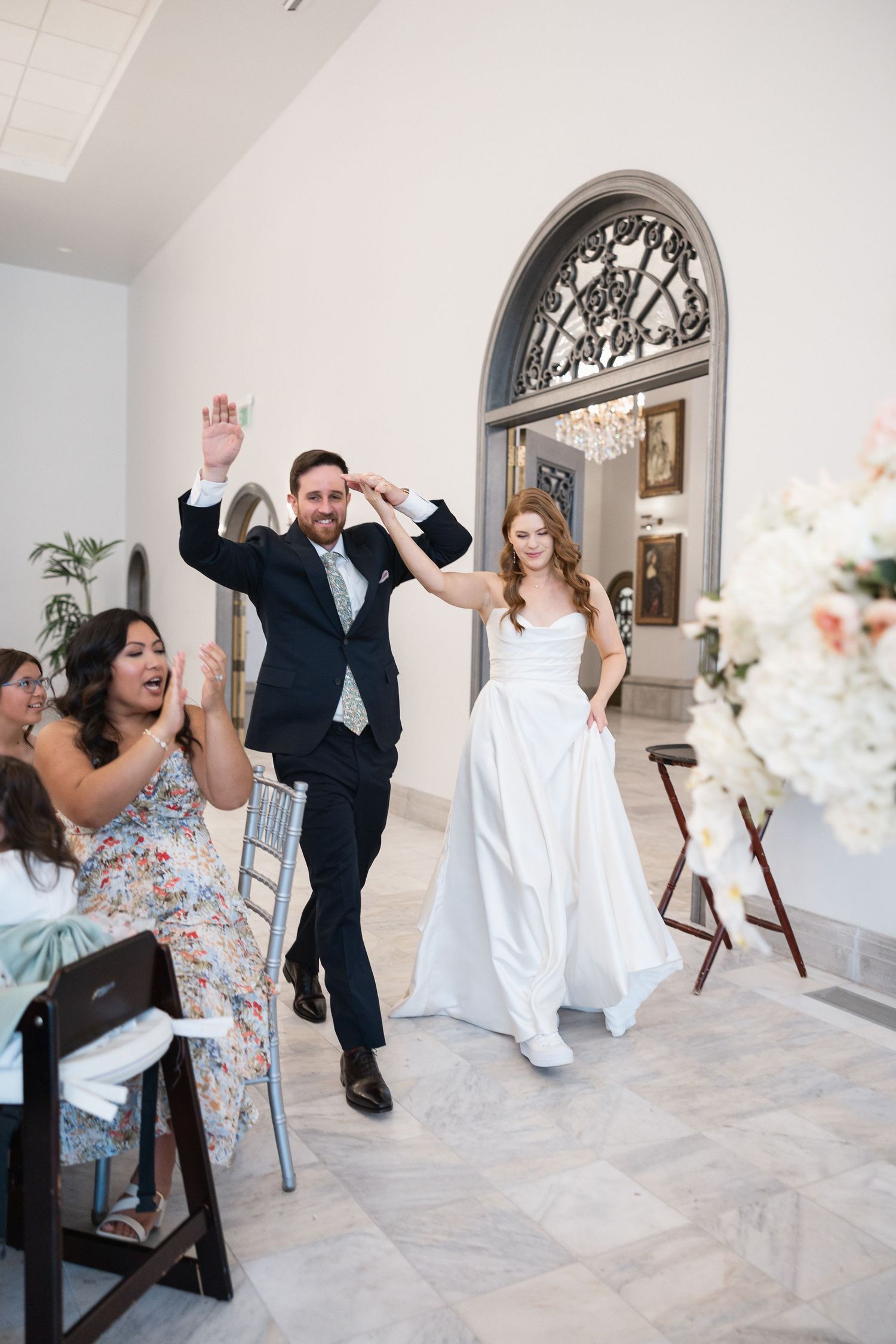 Joyful dancing and celebration moments during a wedding reception in a bright venue.