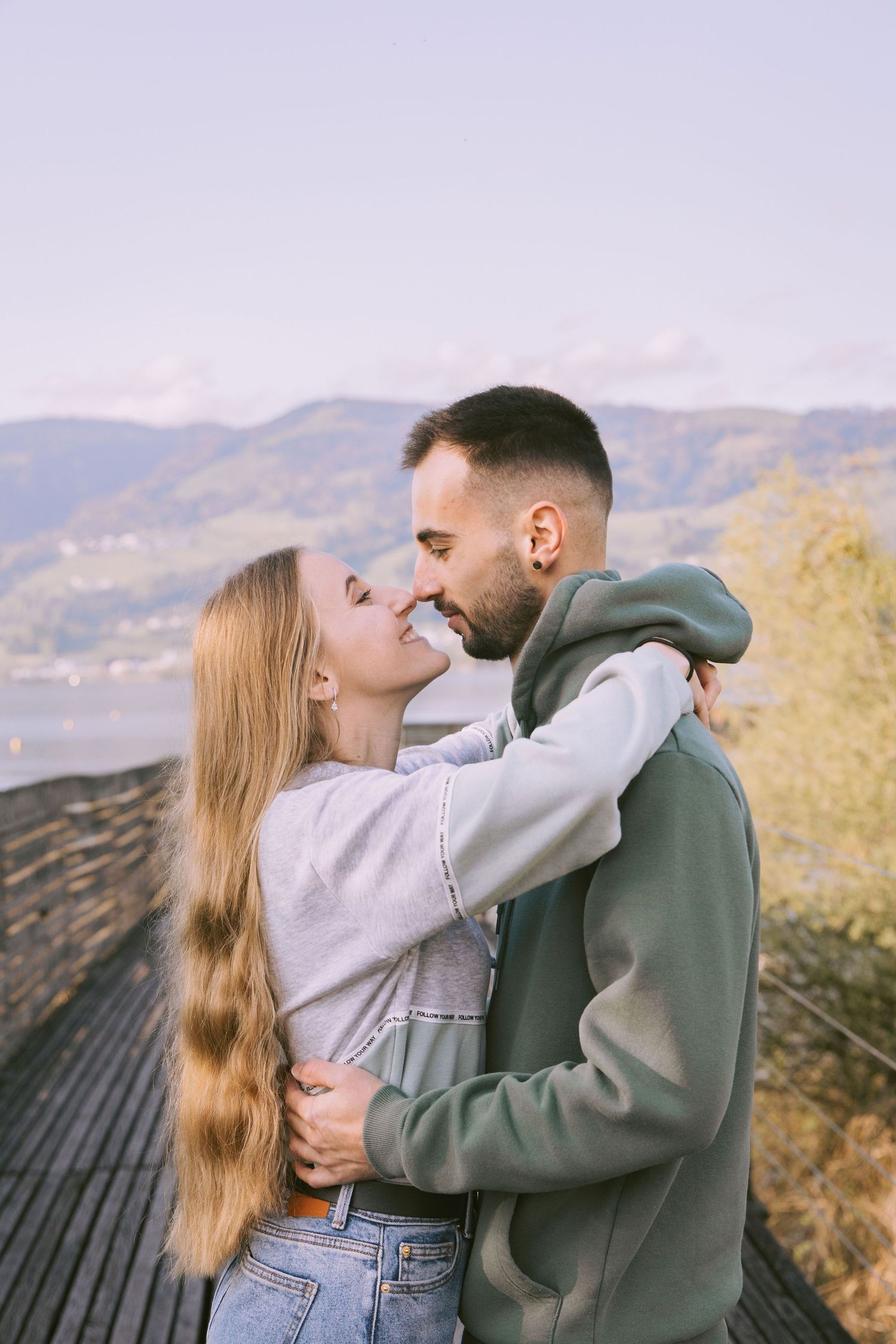 Couple kissing on a bridge during an intimate lifestyle photoshoot.