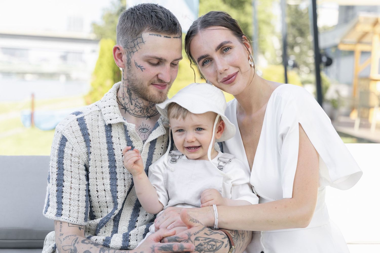Parents posing with their son during a birthday celebration photoshoot.