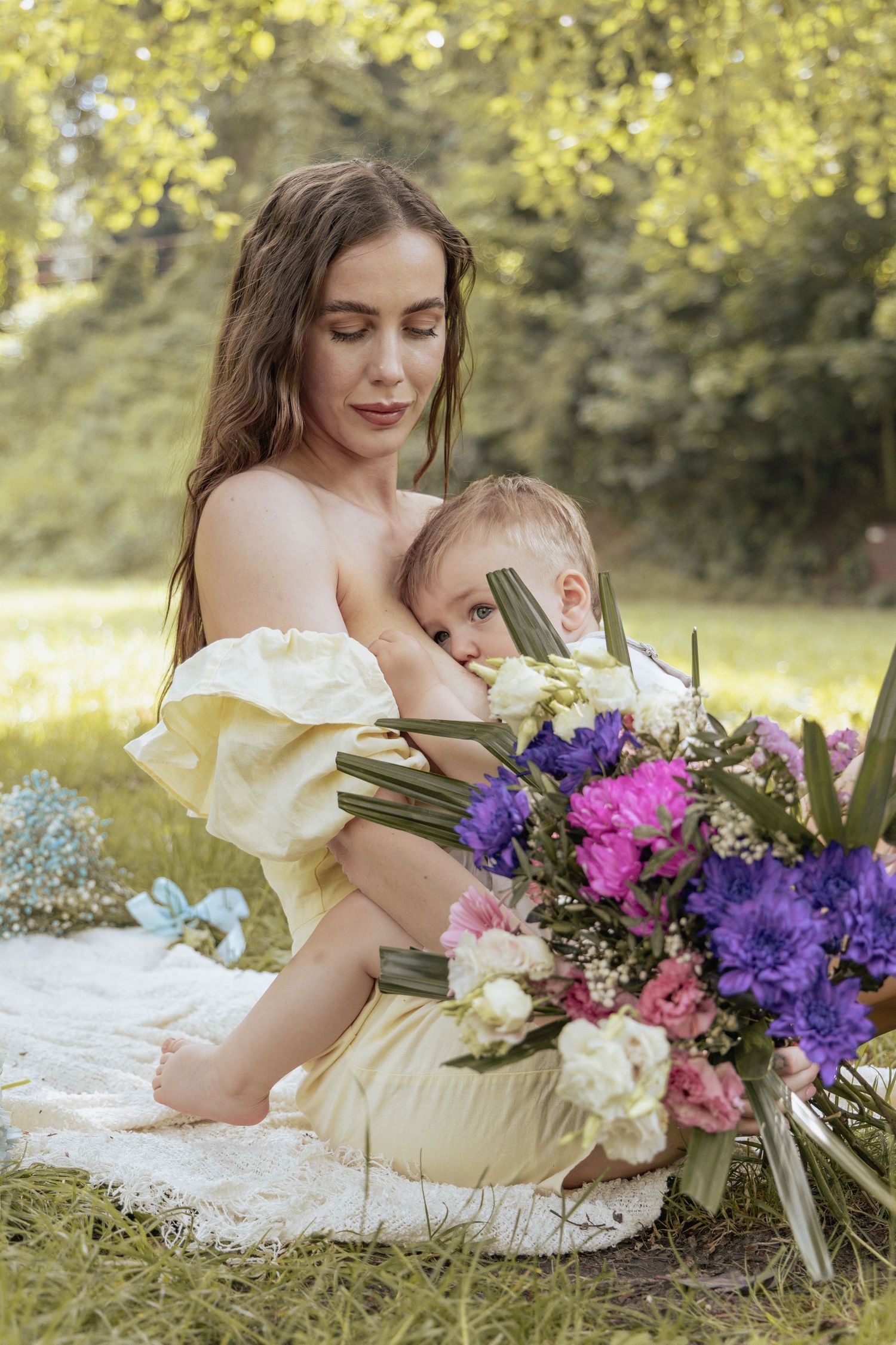 Mother breast-feeding her son in the park.