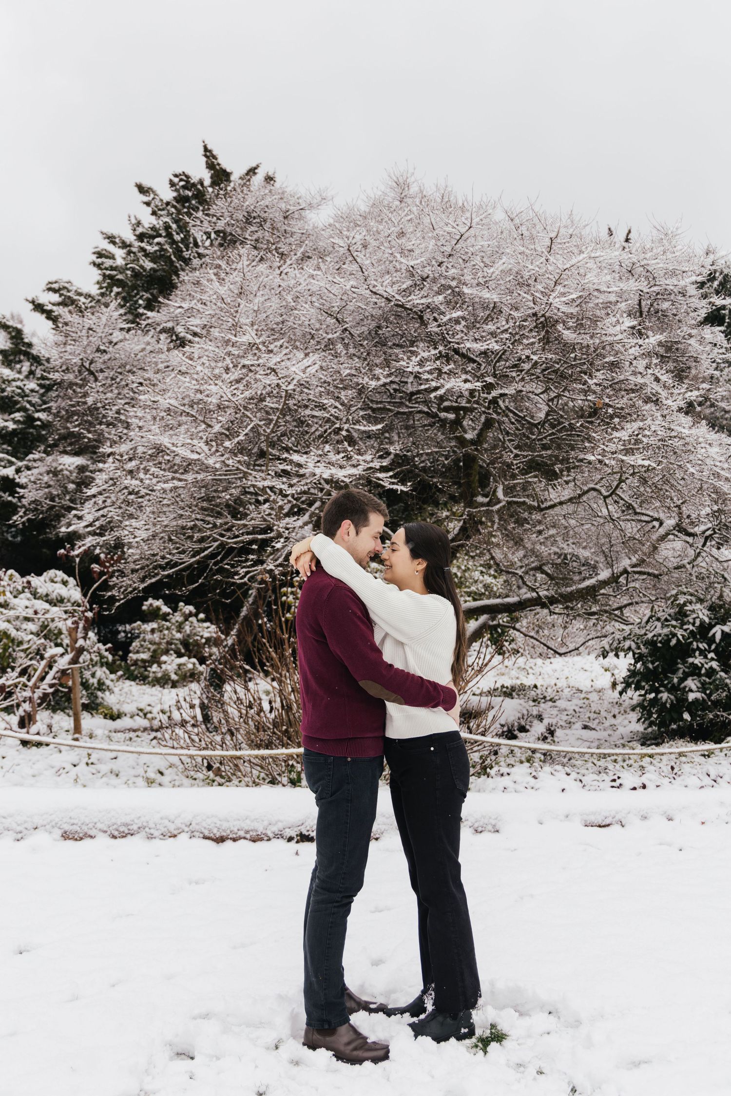 Couple hugging and kissing in the snow during an intimate winter photoshoot in Switzerland.