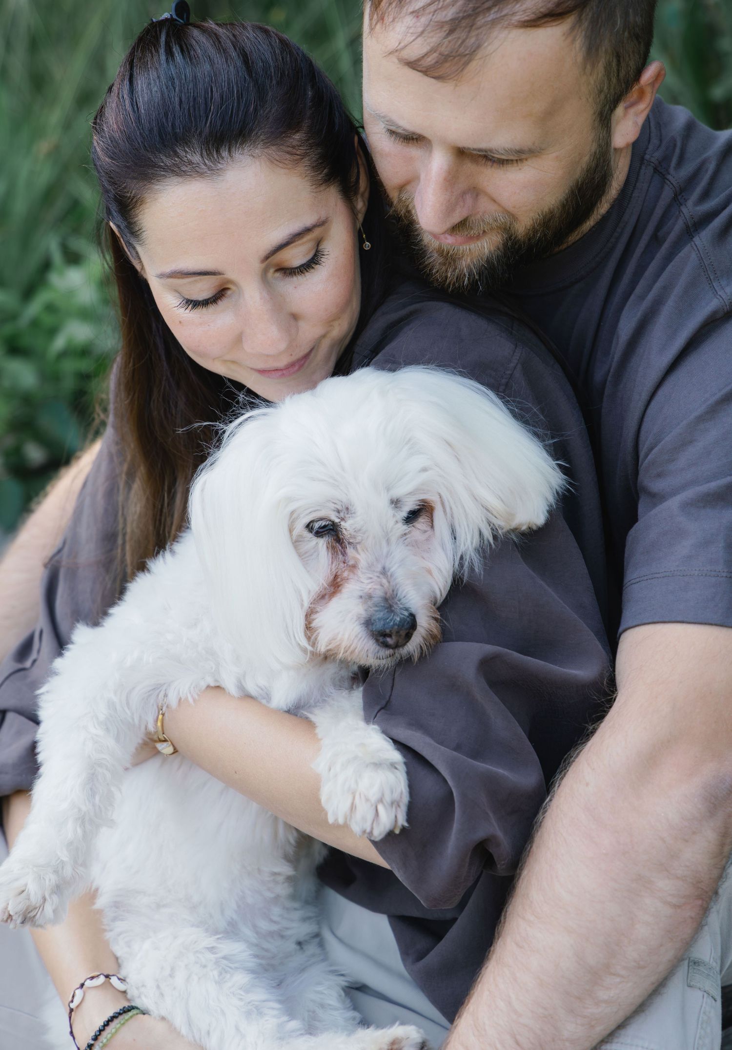 Close-up portrait of a couple with their senior dog during a lifestyle family photoshoot.