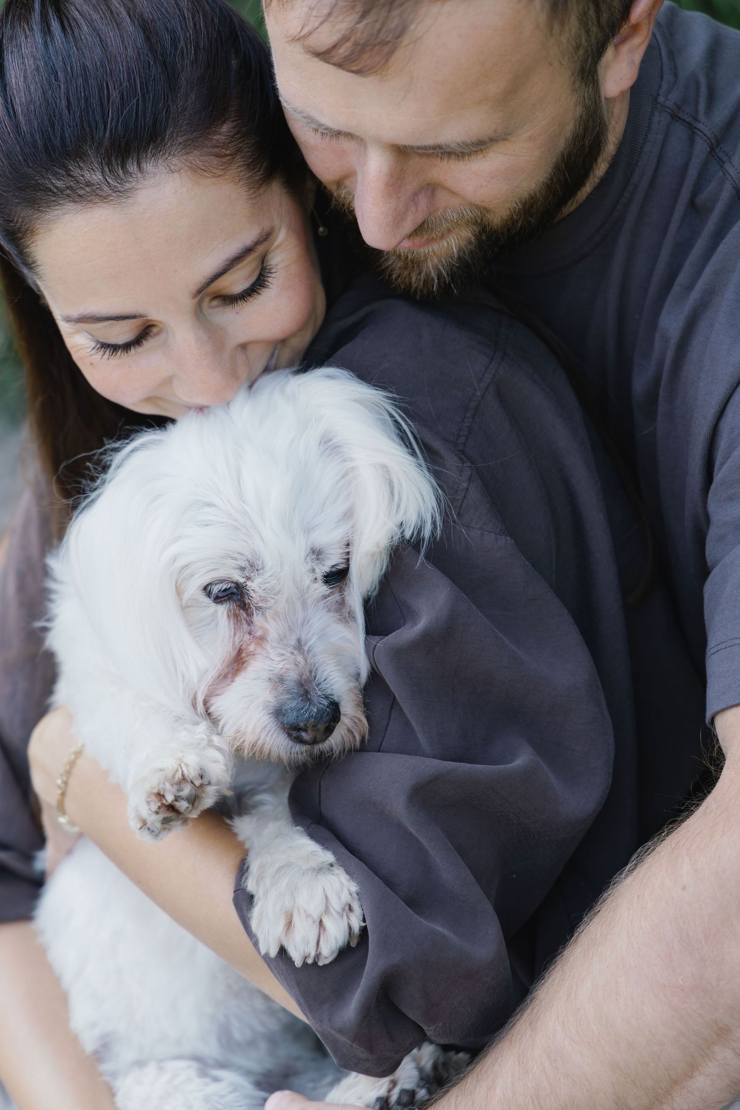 Close-up portrait of a couple with their senior dog during a lifestyle family photoshoot.