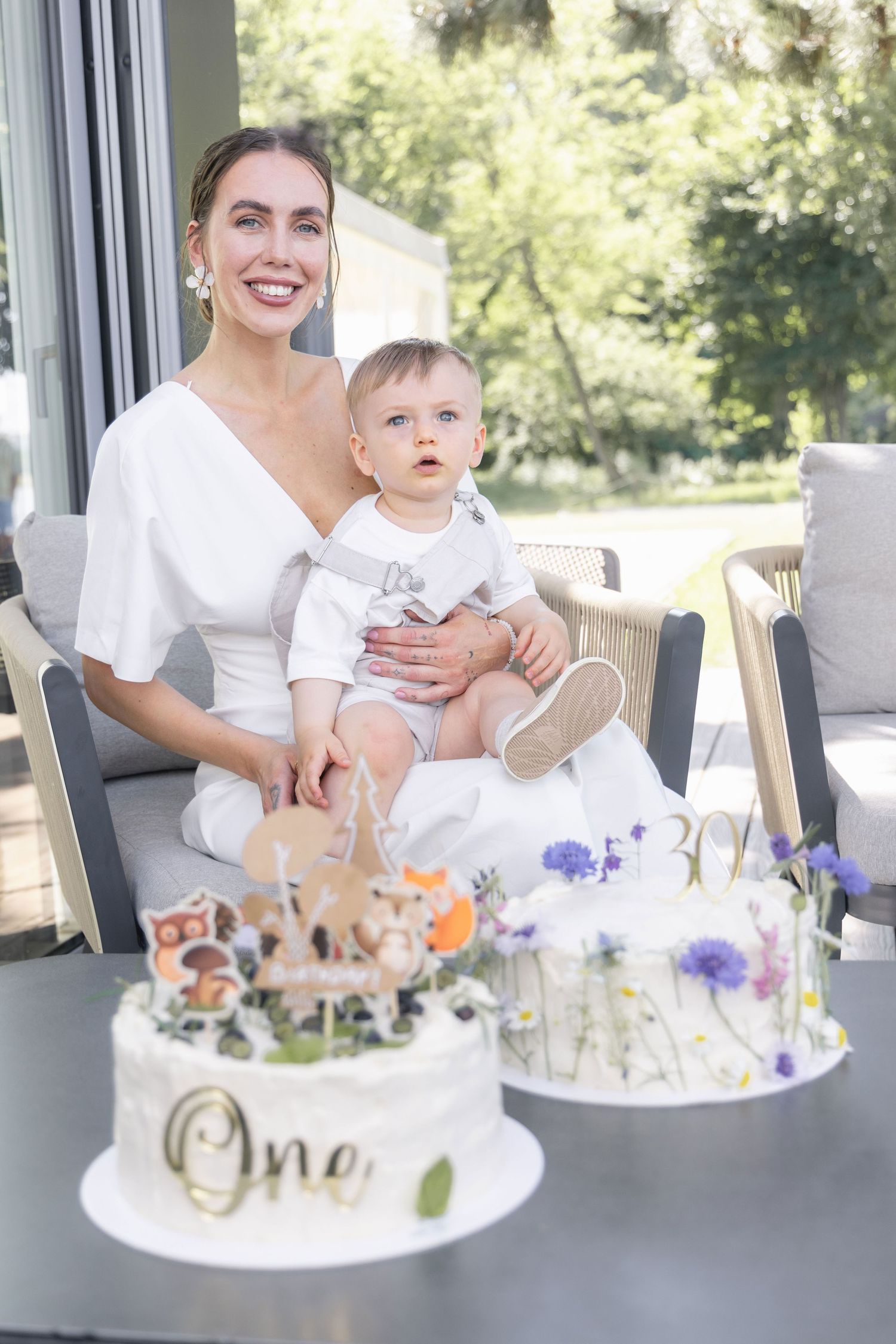 Mother and son sitting in front of birthday cakes during a family birthday photoshoot.