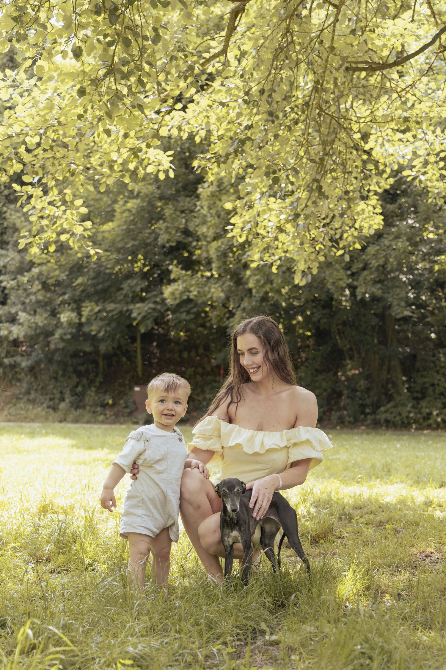Mother, son, and their dog together during relaxed family photoshoot.