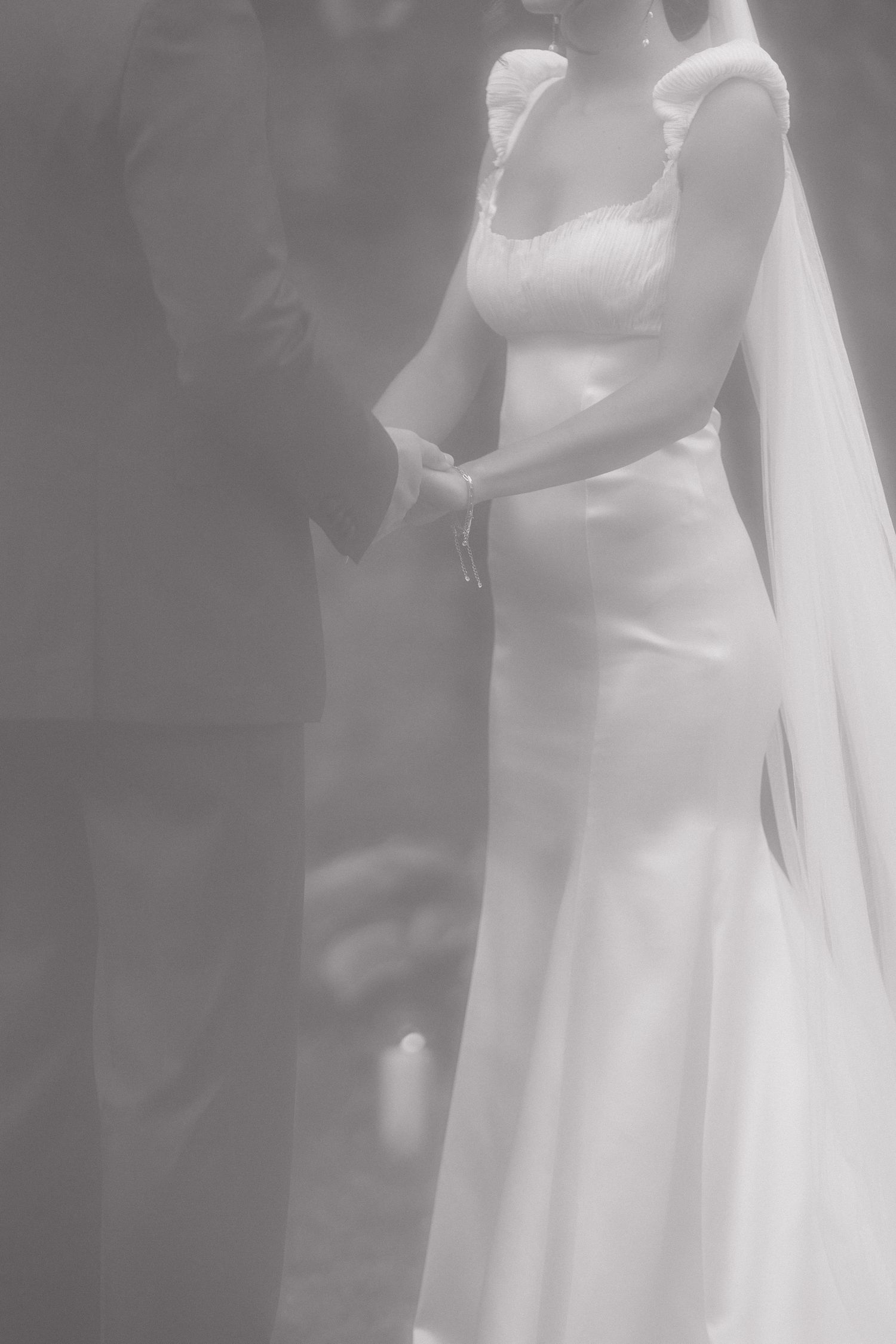 Intimate black and white wedding portrait showing couple in soft focus.