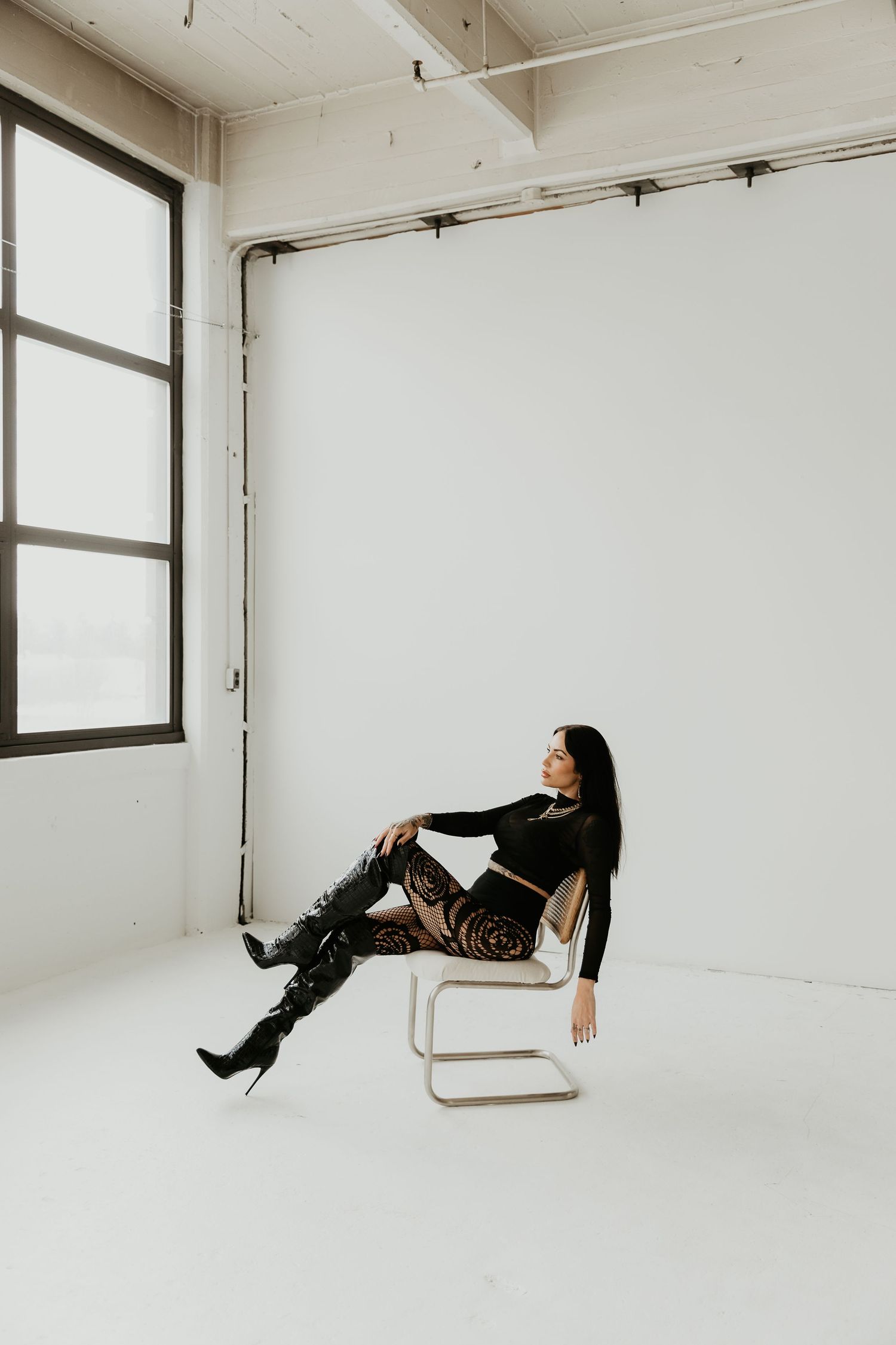 A sequence of four minimalist photos showing a figure in black clothing reclining in different positions against white walls.