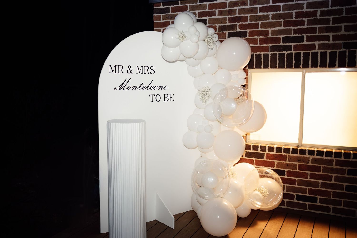 White arch sign reading Mr & Mrs Monteleone To Be with balloon garland decor.