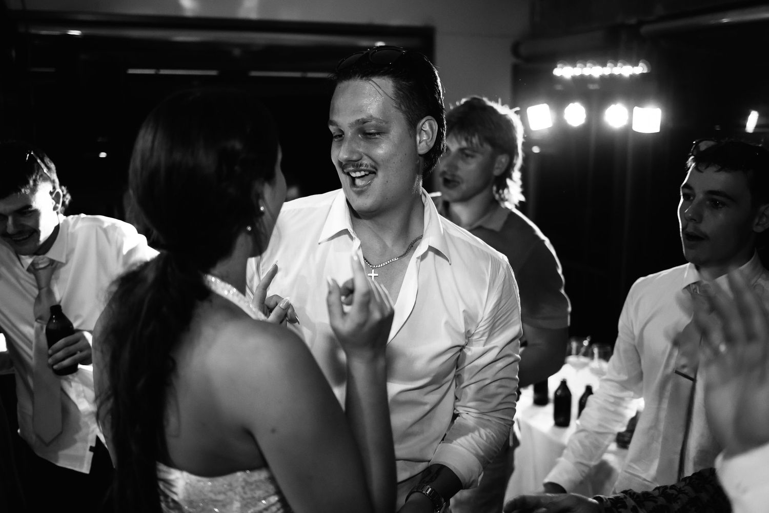 Couple sharing a joyful dance together at wedding reception in black and white.