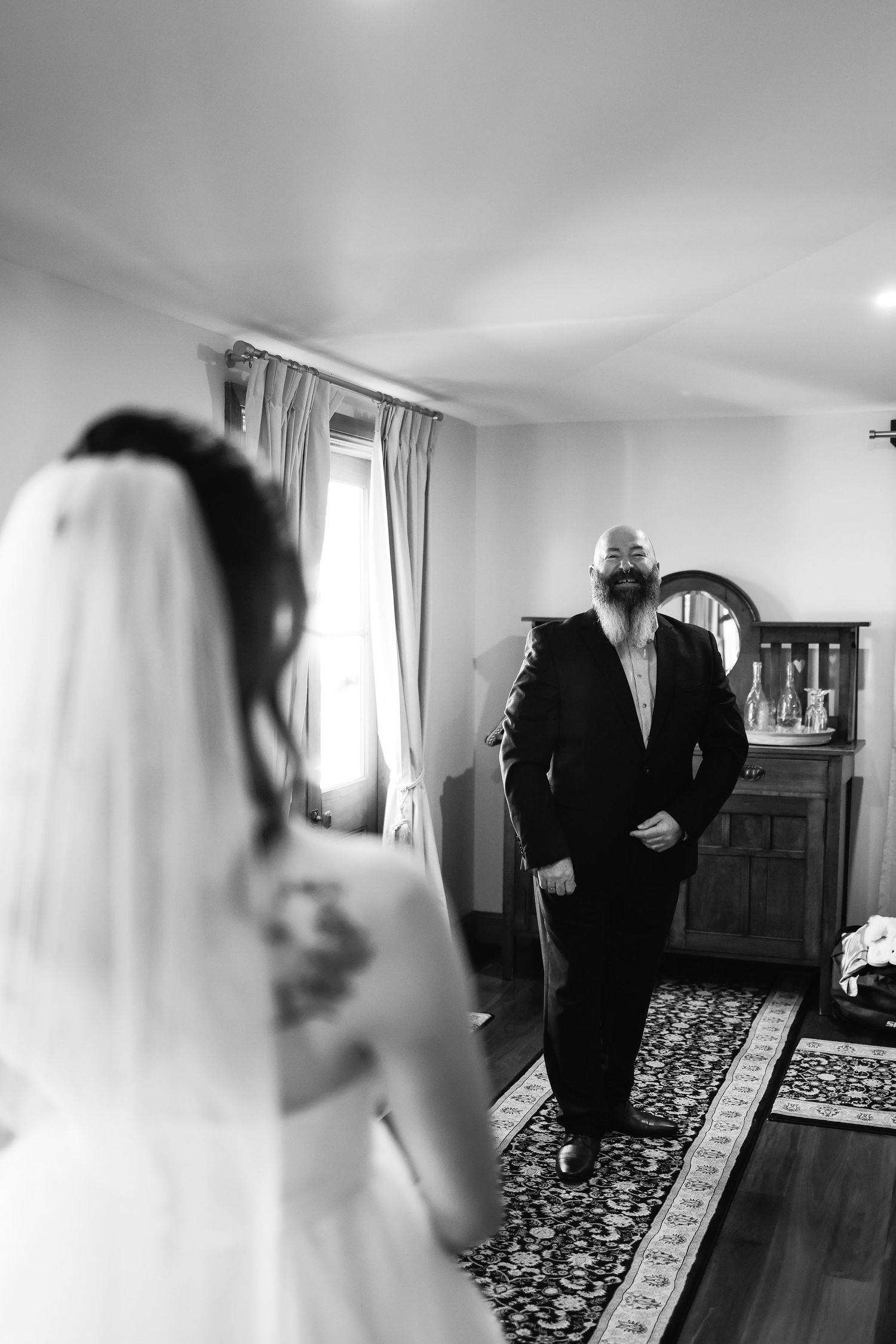 Black and white photo of a groom seeing his bride for the first time on their wedding day.