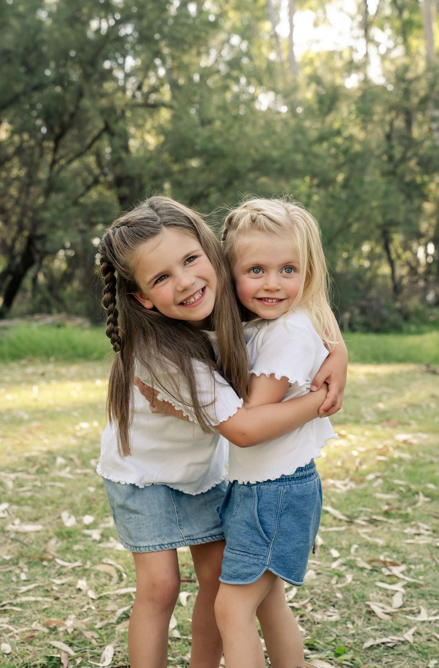 Two sisters giving each other a cuddle and smiling at a photoshoot at Thompsons Beach Cobram