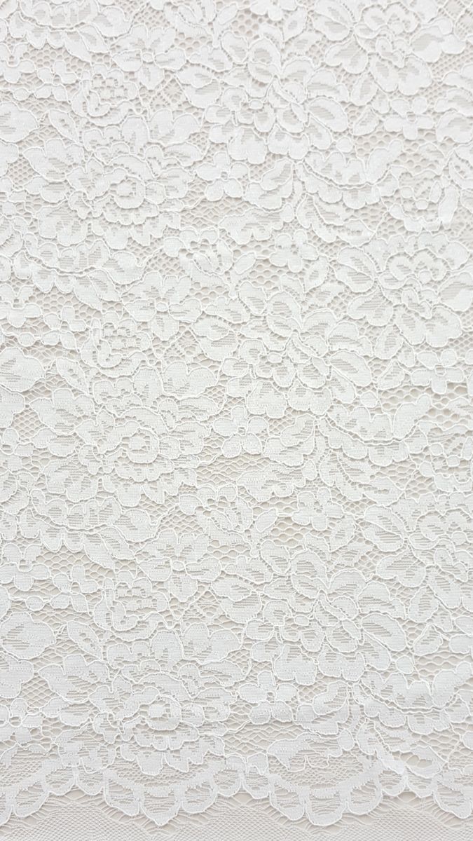 Elegant white floral lace fabric texture with intricate scalloped border detail.