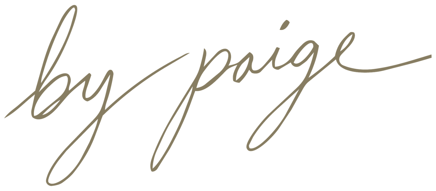 Elegant cursive signature reading by paige in gold script on white background.